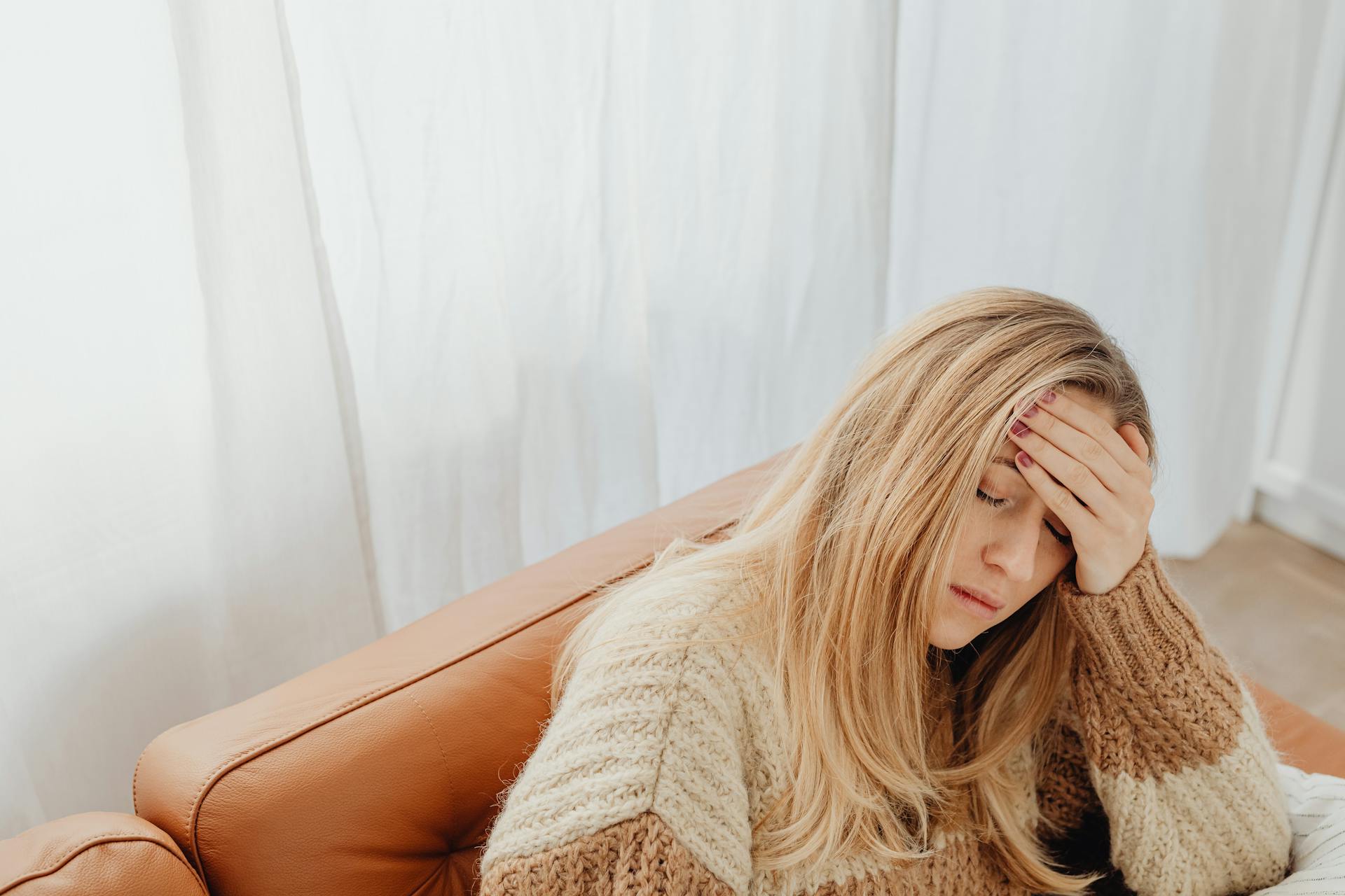 Une femme fatiguée assise sur un canapé | Source : Pexels