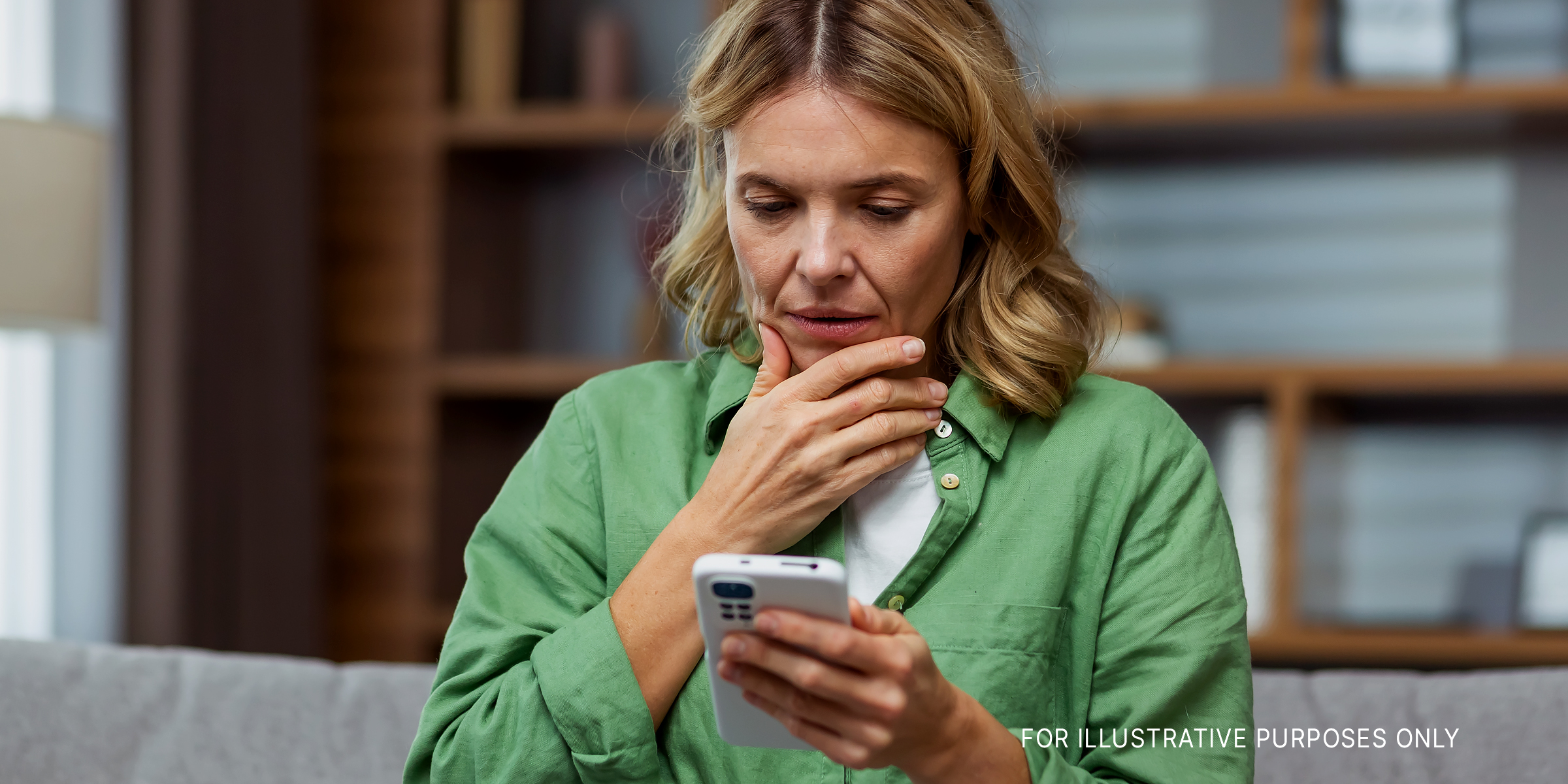 Femme regardant son téléphone, perplexe | Source : Shutterstock