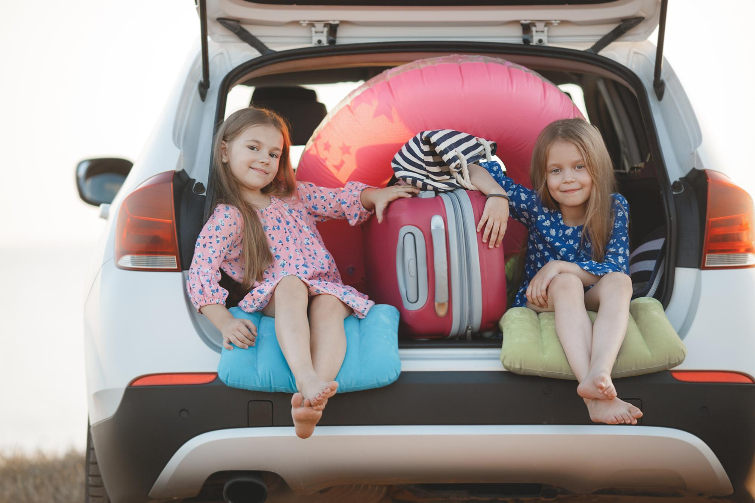 Deux petites filles assises dans un coffre de voiture | Source : Freepik
