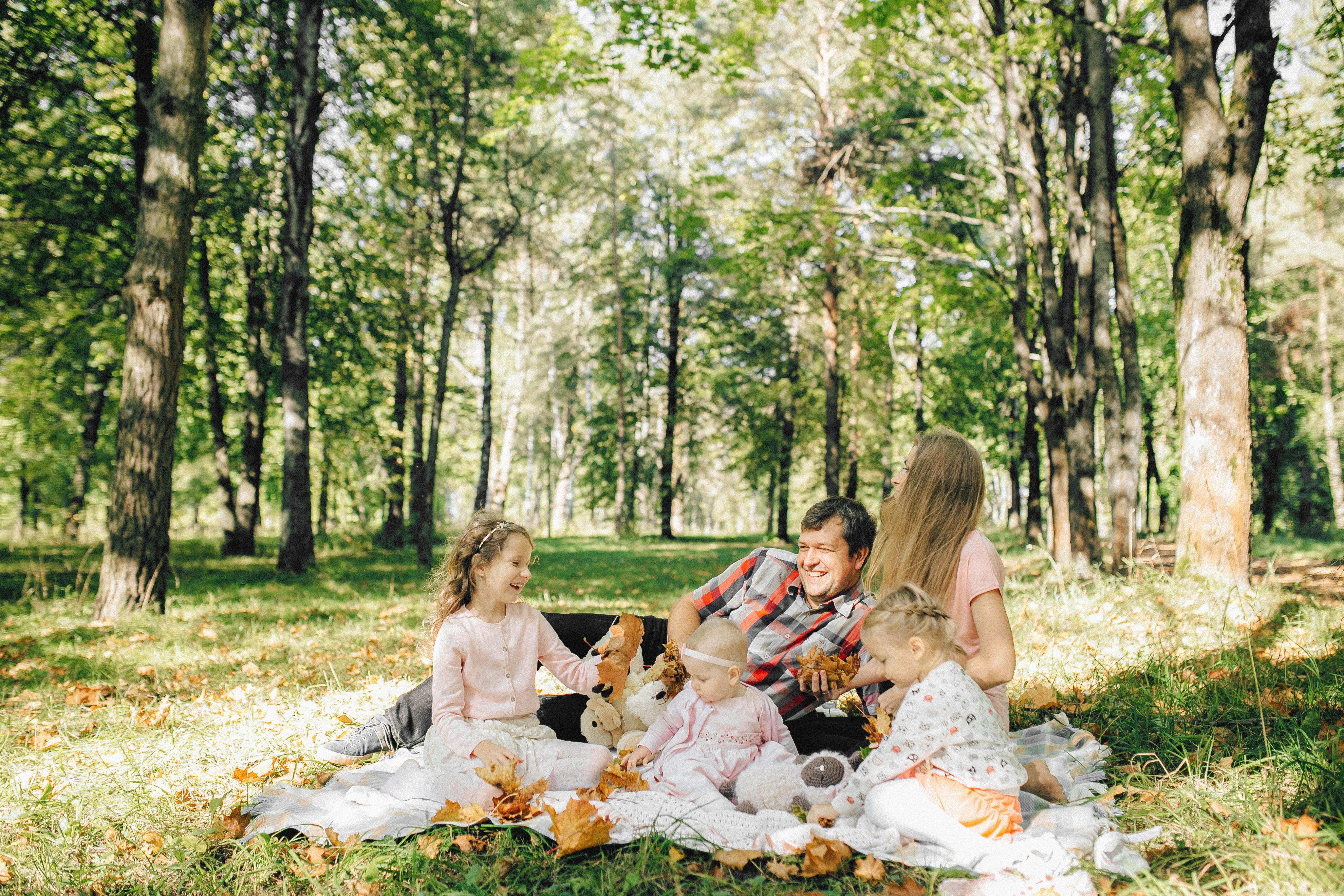 Des parents et leurs trois jeunes enfants profitent d'un pique-nique | Source : Pexels