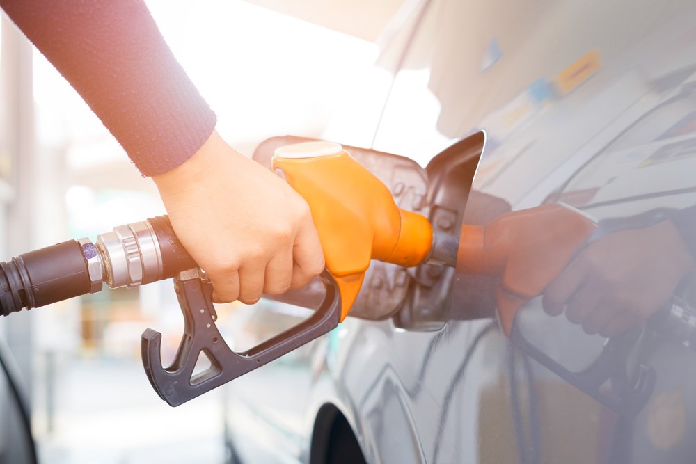 Une voiture grise se faisant remplir de carburant à la station d’essence. | Shutterstock