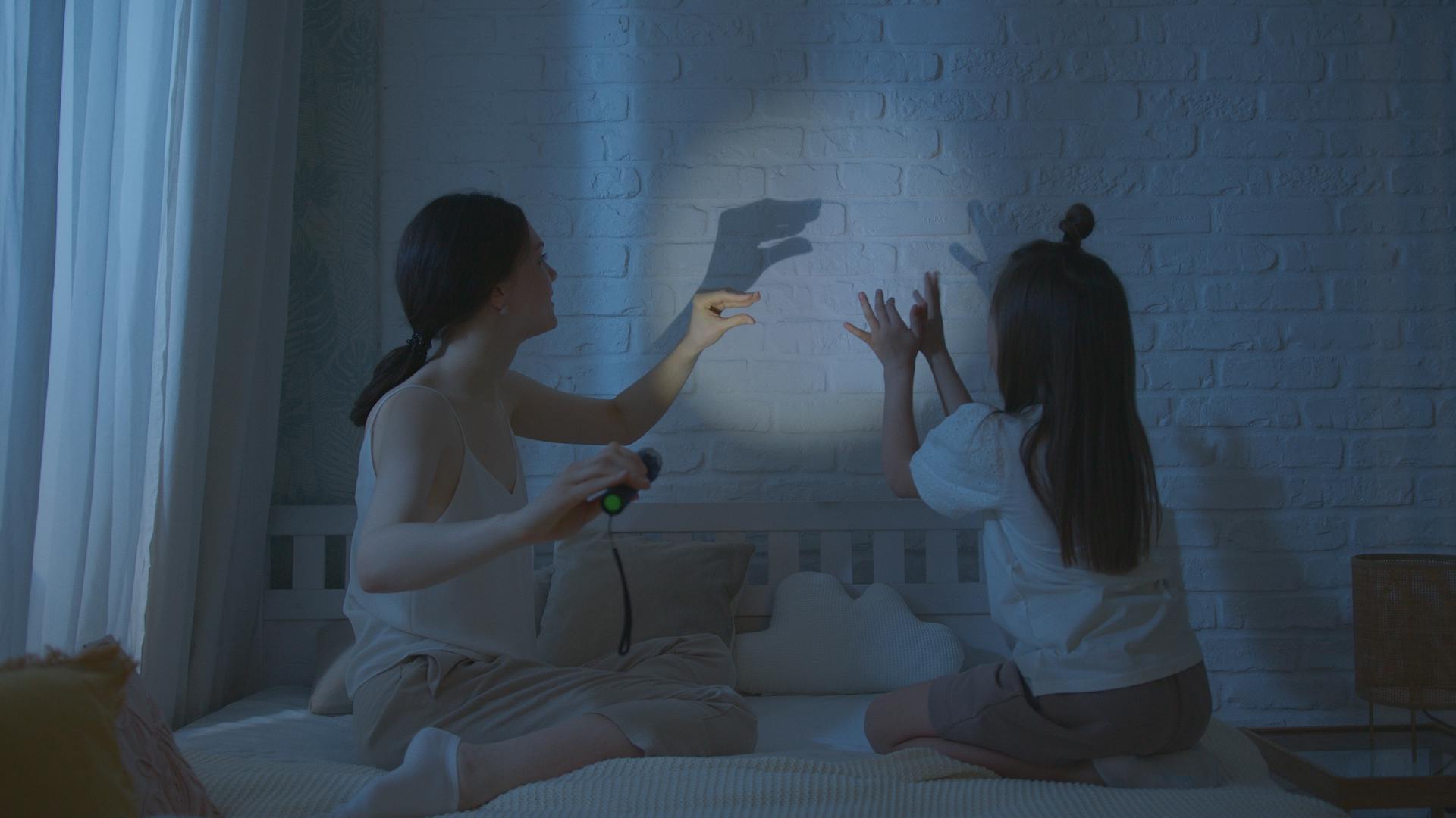 Une femme et sa fille créant des ombres chinoises | Source : Pexels
