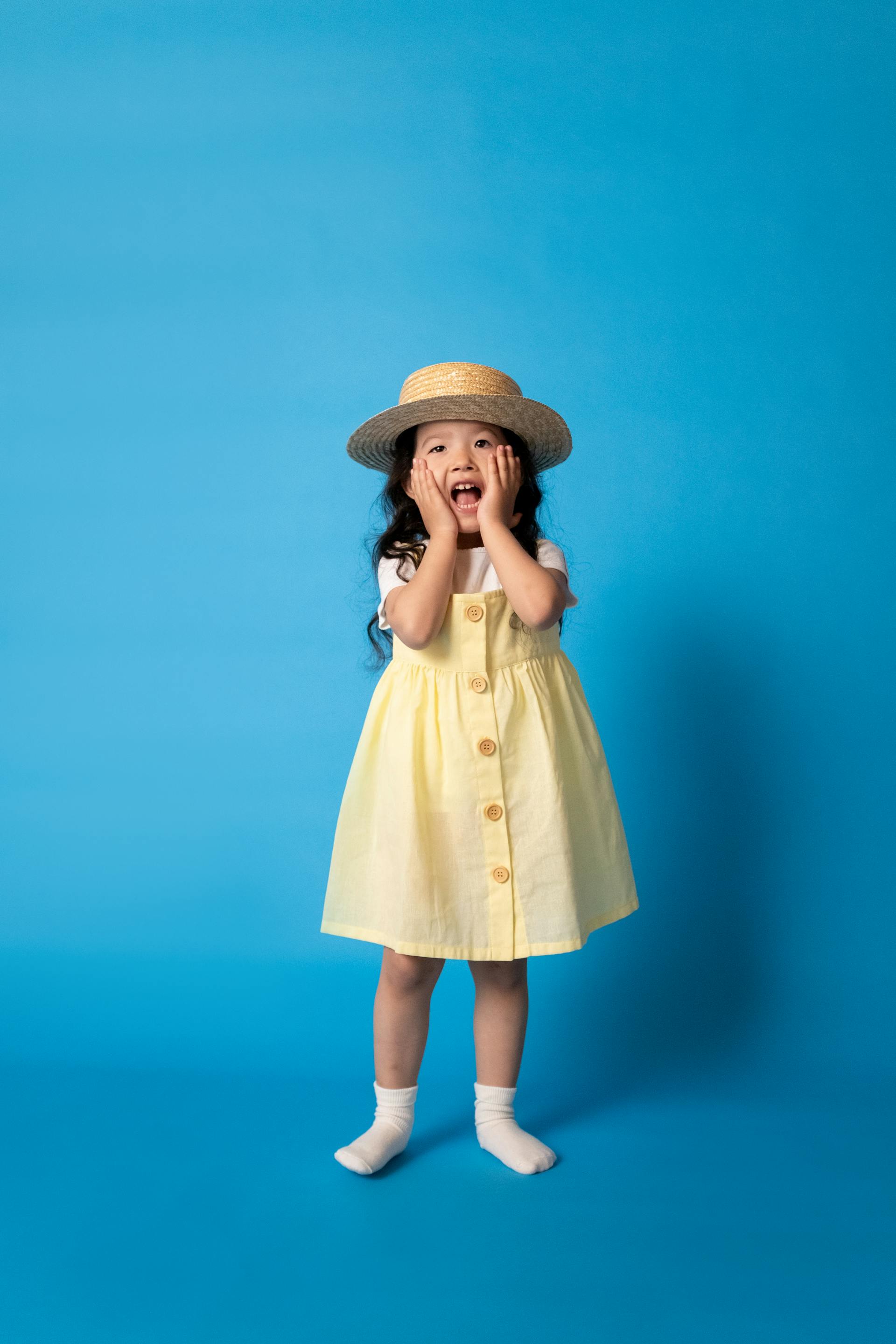 Une petite fille qui tient ses joues | Source : Pexels
