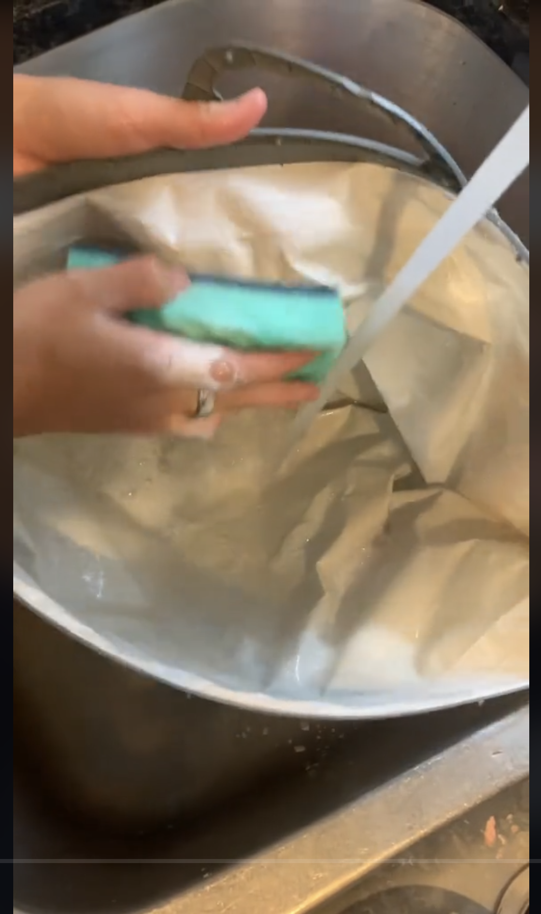 Une personne lave un sac d'épicerie réutilisable avec de l'eau savonneuse, comme on peut le voir dans une vidéo datée du 22 septembre 2023 | Source : TikTok/@consumerreports