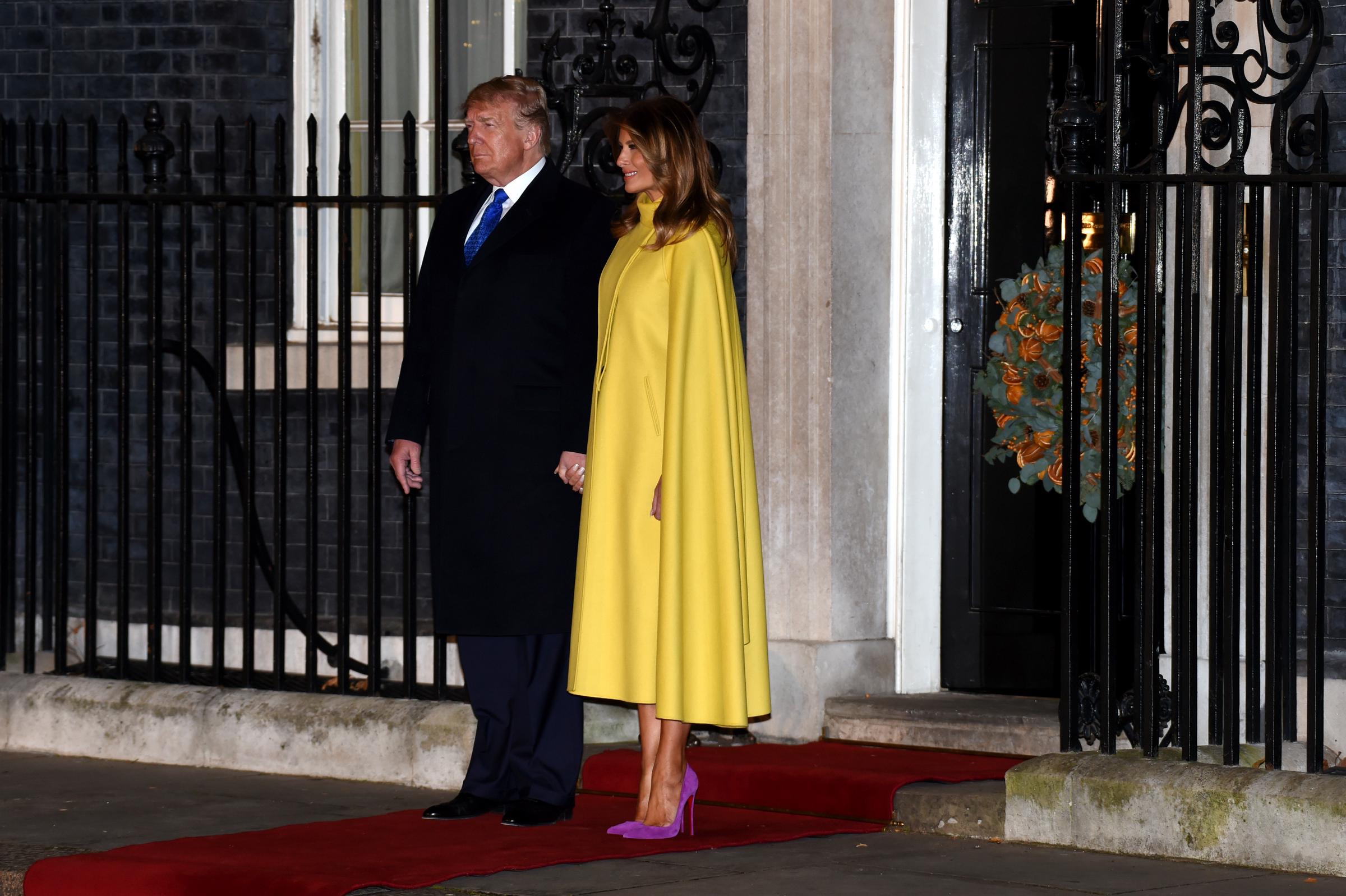 La Première dame Melania Trump a assisté à la réception organisée dans le cadre du sommet de l'OTAN au 10 Downing Street à Londres en décembre 2019, arborant un look spectaculaire aux couleurs contrastées : un manteau-cape Valentino jaune vif associé à des escarpins à bout pointu en daim magenta signés Christian Louboutin.