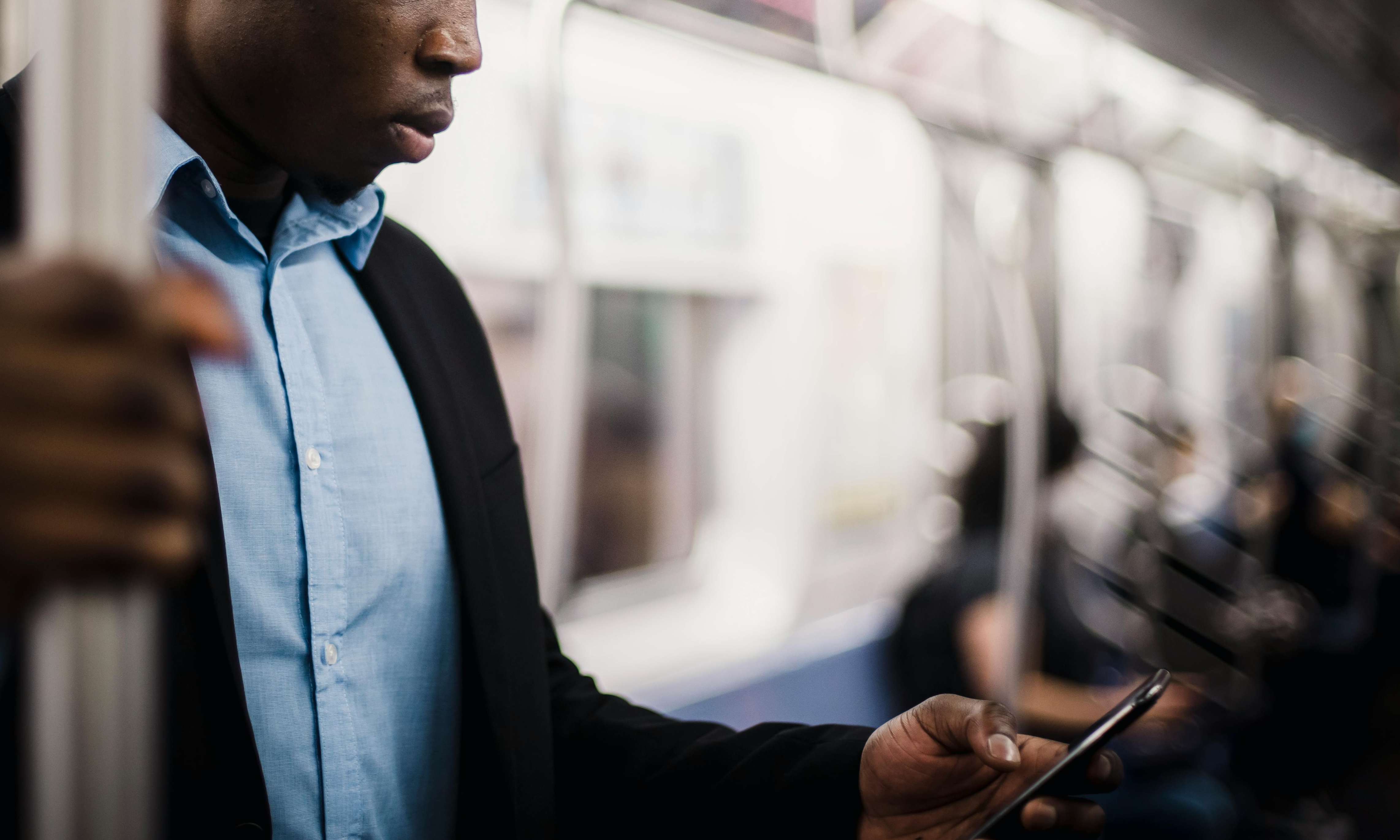 Un homme regardant son téléphone portable dans un wagon de métro | Source : Pexels