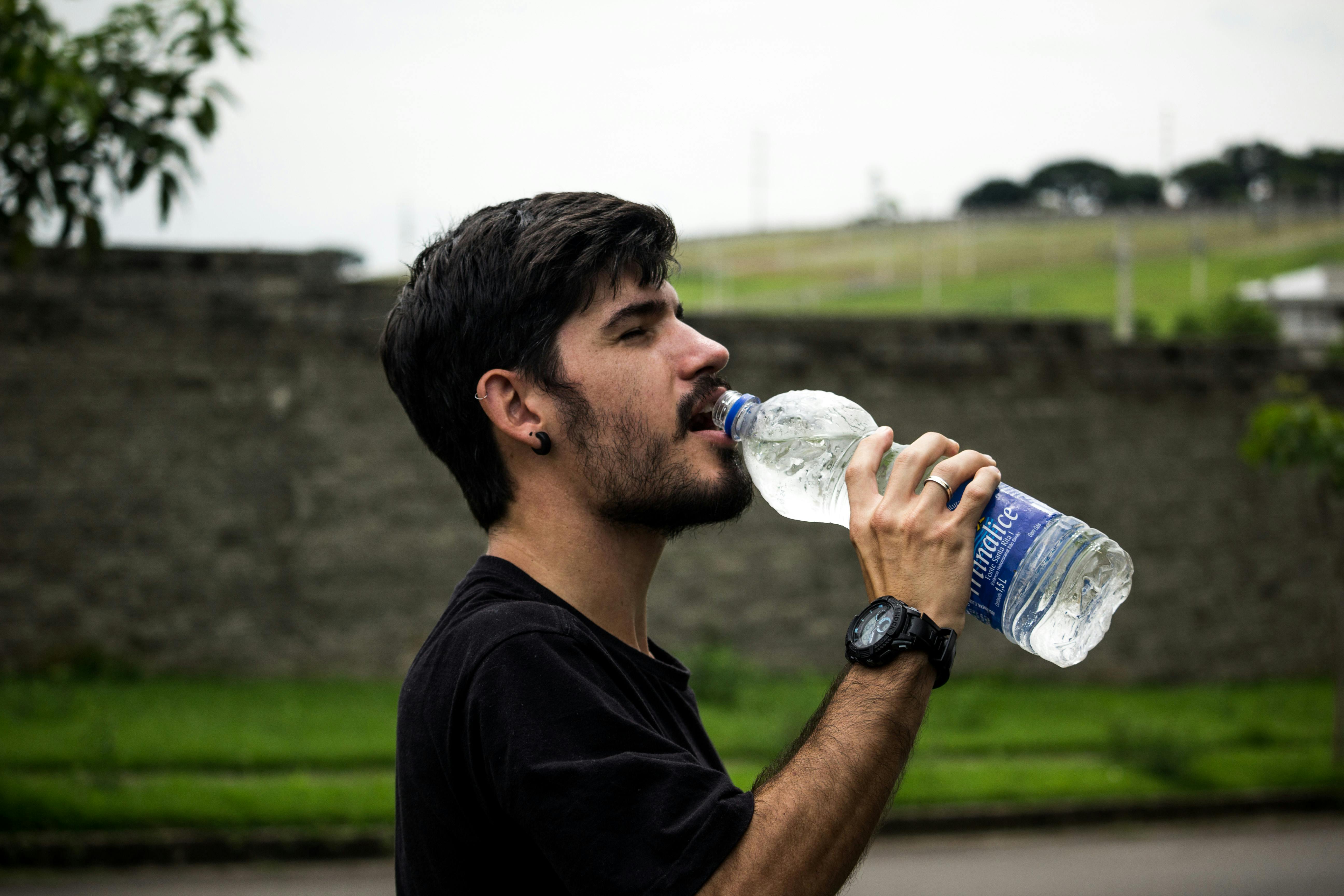 Un homme boit de l'eau | Source : Pexels