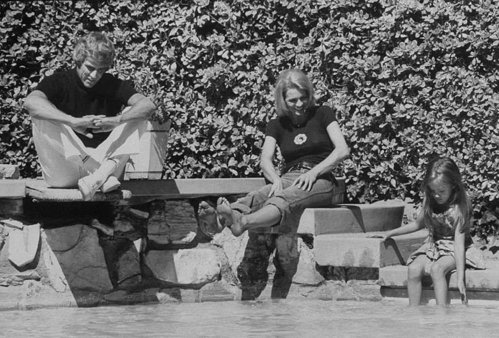 Le compositeur Burt Bacharach Jr. (à gauche) et son épouse actrice Angie Dickinson regardant leur fille jouer dans l'eau à Hollywood en 1974. | Source : Getty Images