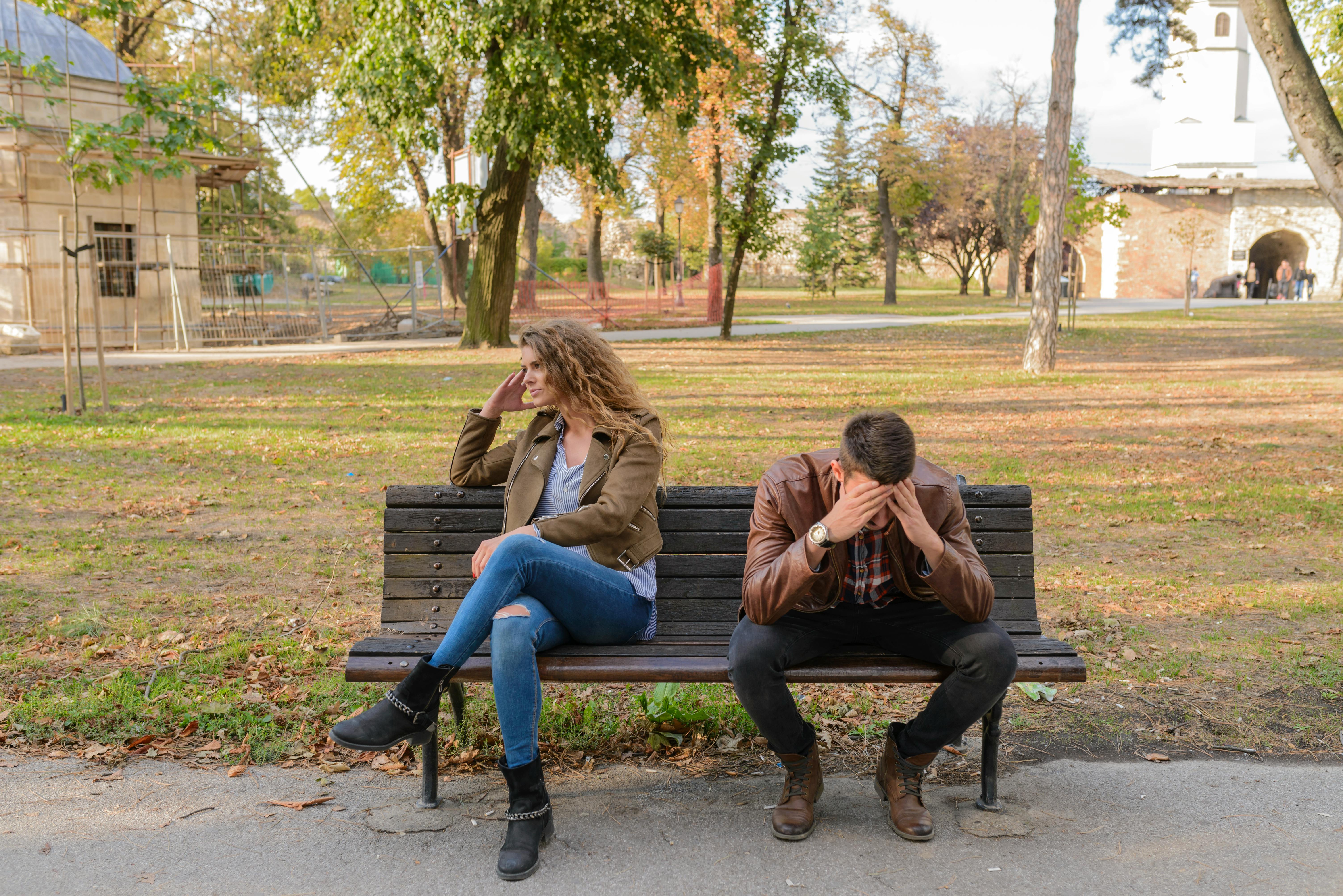 Une femme en colère assise à côté d'un homme en pleurs sur un banc public | Source : Pexels