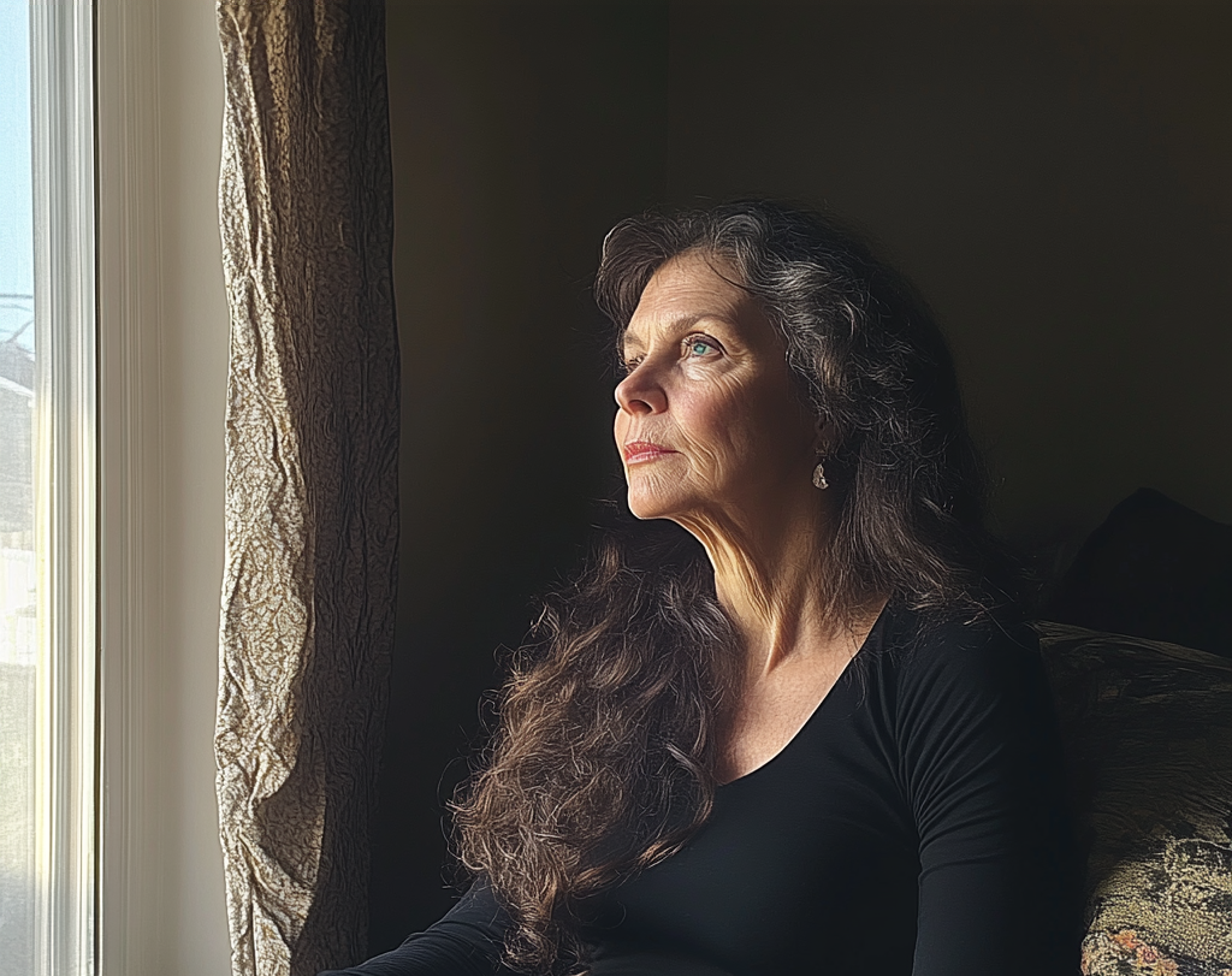 Une femme âgée qui regarde par la fenêtre | Source : Midjourney