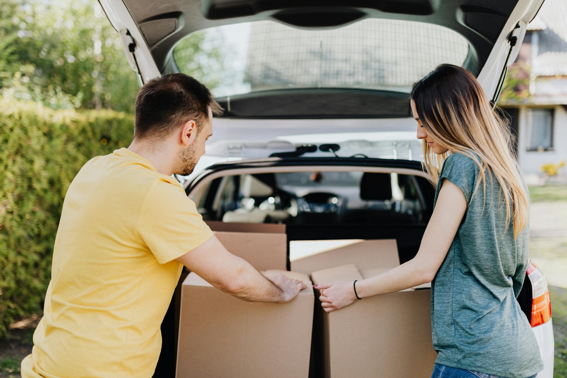 Un couple déchargeant des cartons de leur voiture | Source : Pexels