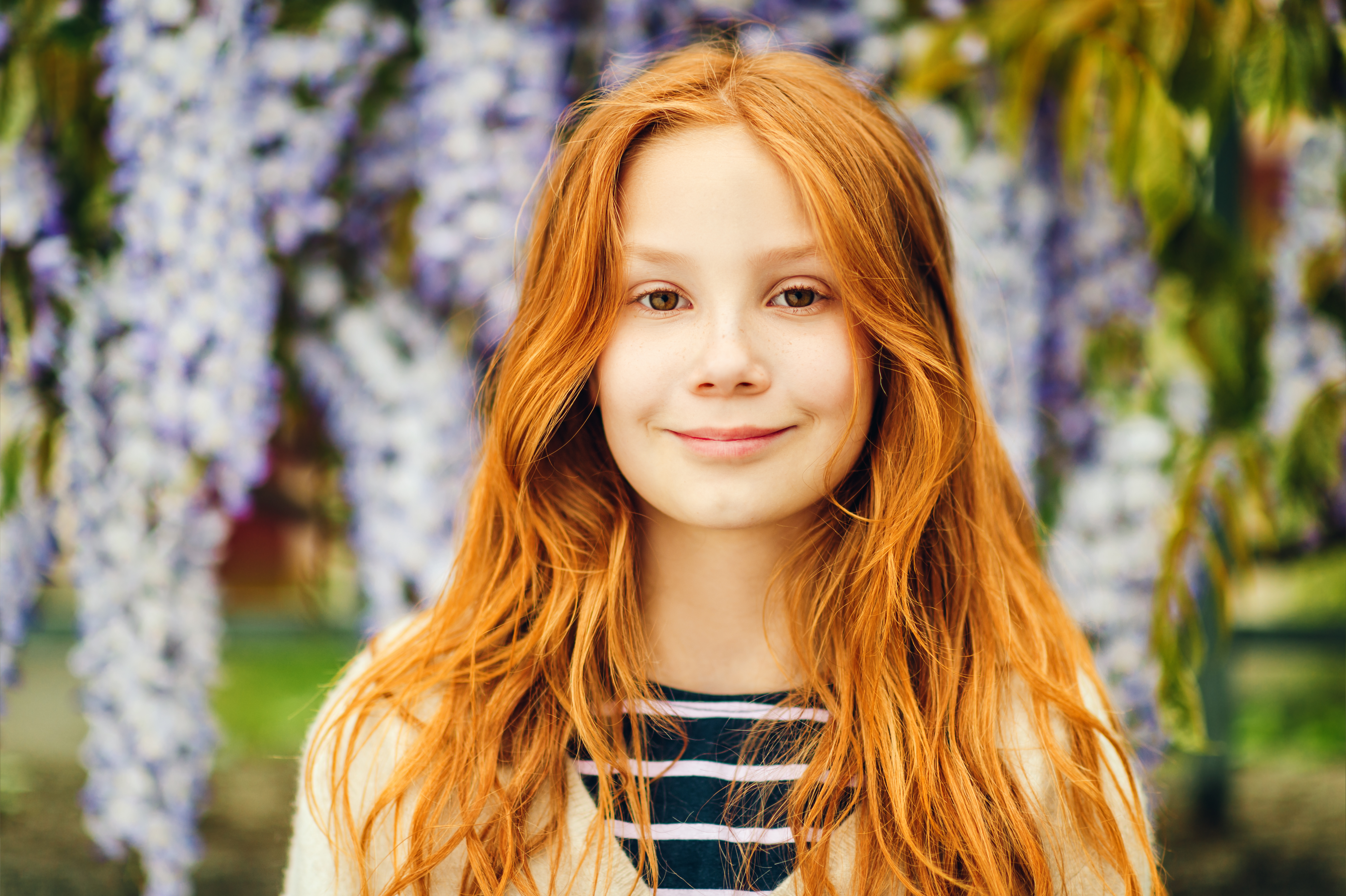 Une jeune fille souriant devant une glycine | Source : Shutterstock