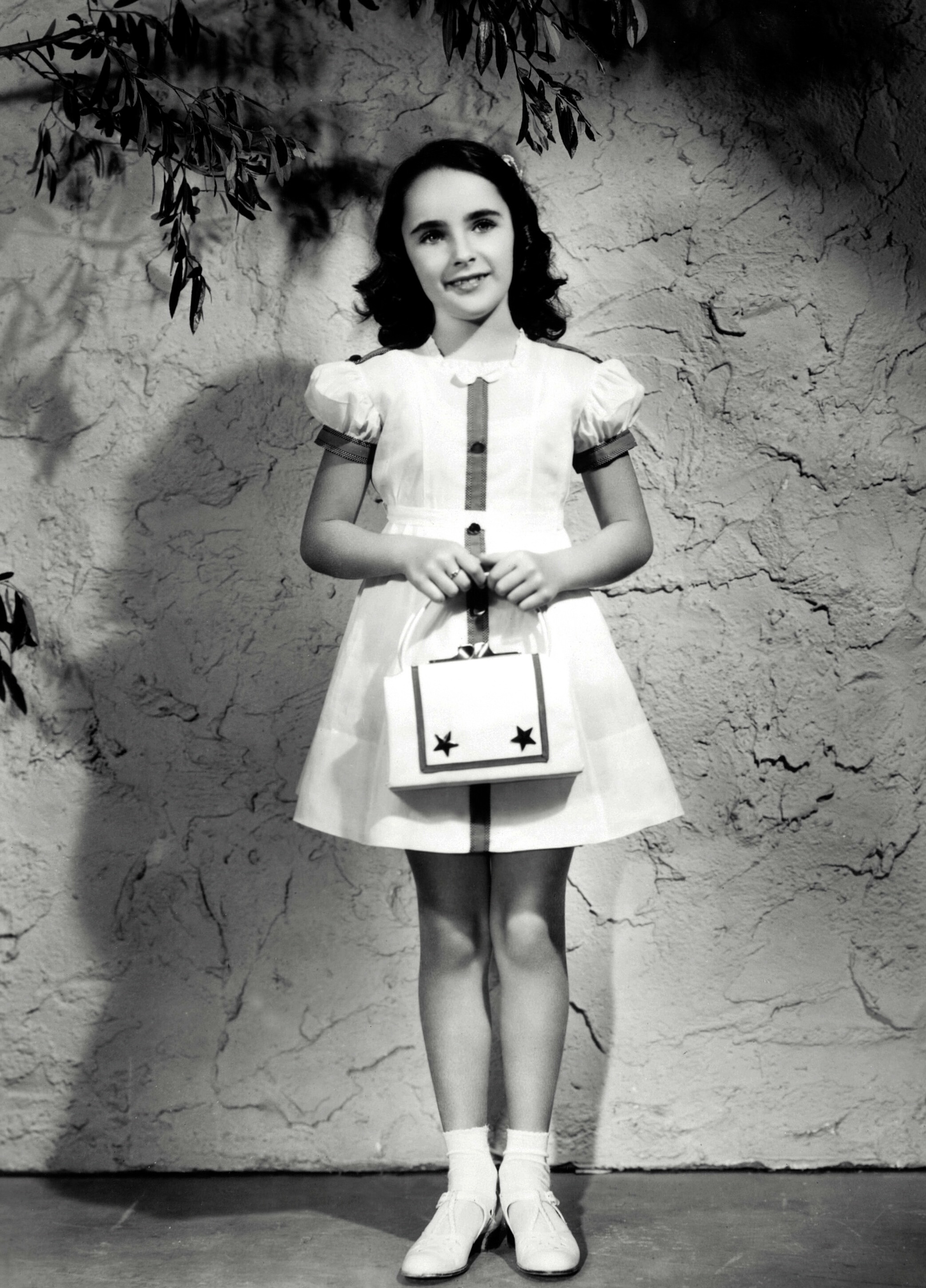 L'enfant star Elizabeth Taylor pose avec un sac à main le 1er janvier 1940 | Source : Getty Images