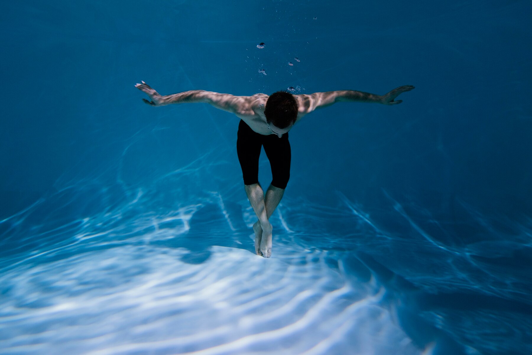 Un homme plongeant dans une piscine | Source : Freepik