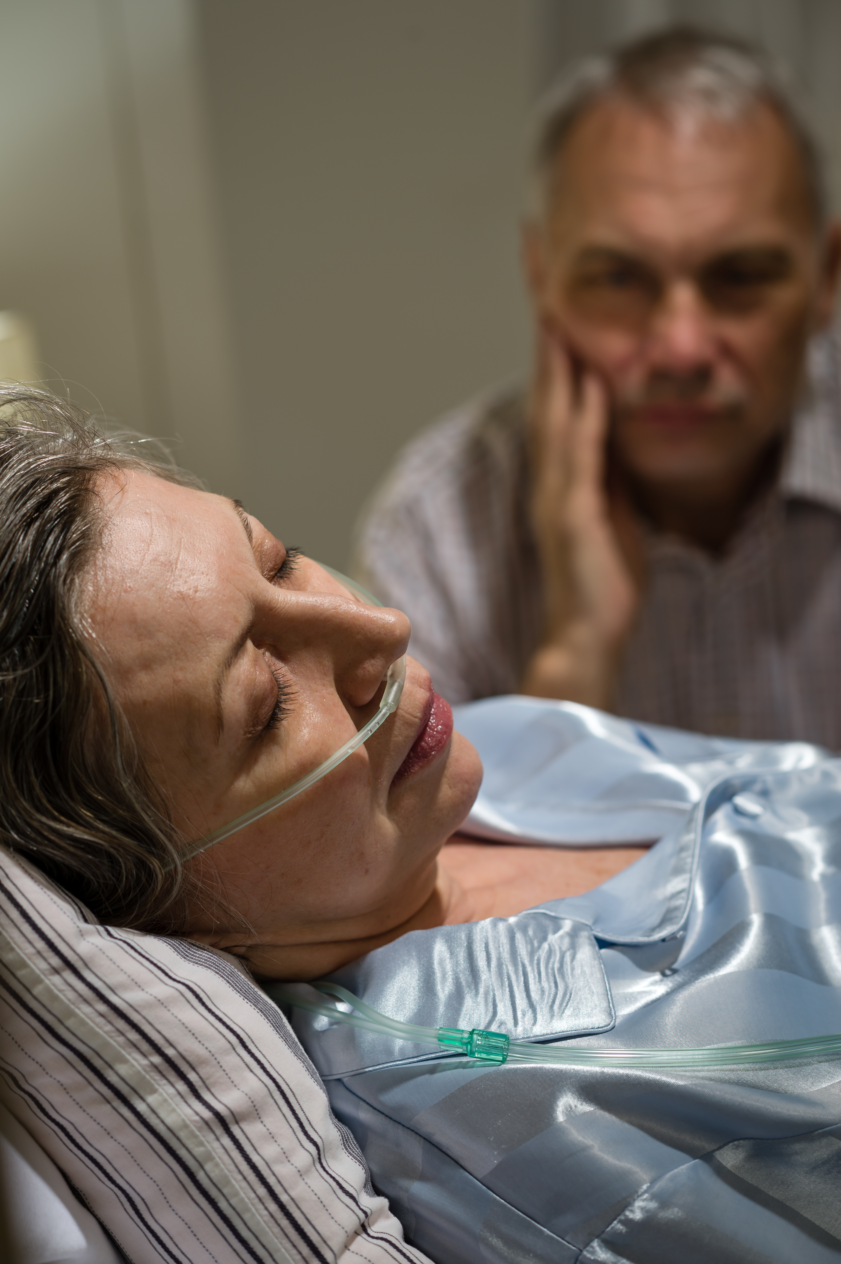 Femme souffrante à l'hôpital avec un homme à ses côtés | Source : Shutterstock