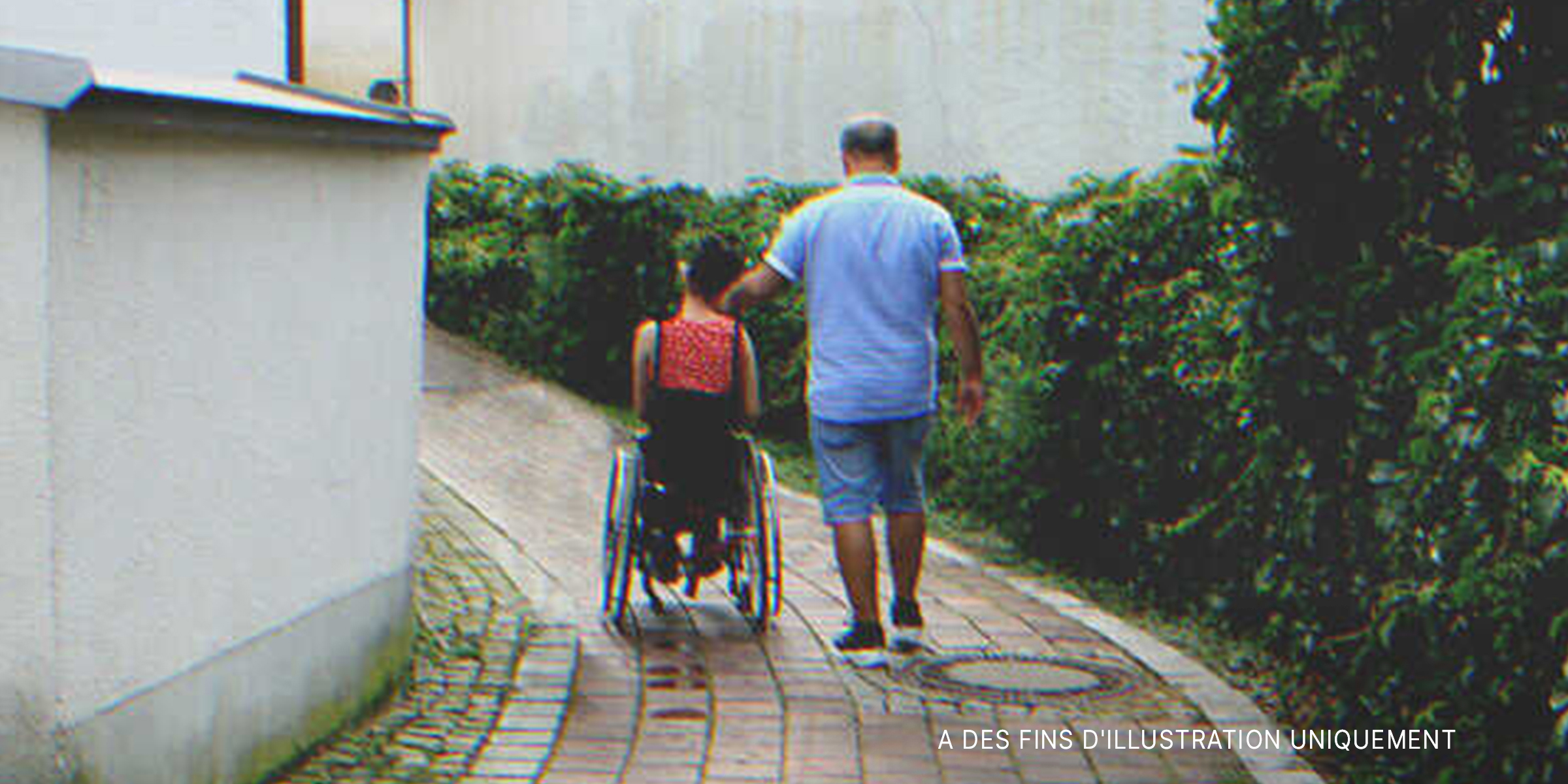 Un homme avec une jeune fille en fauteuil roulant | Source : Shutterstock