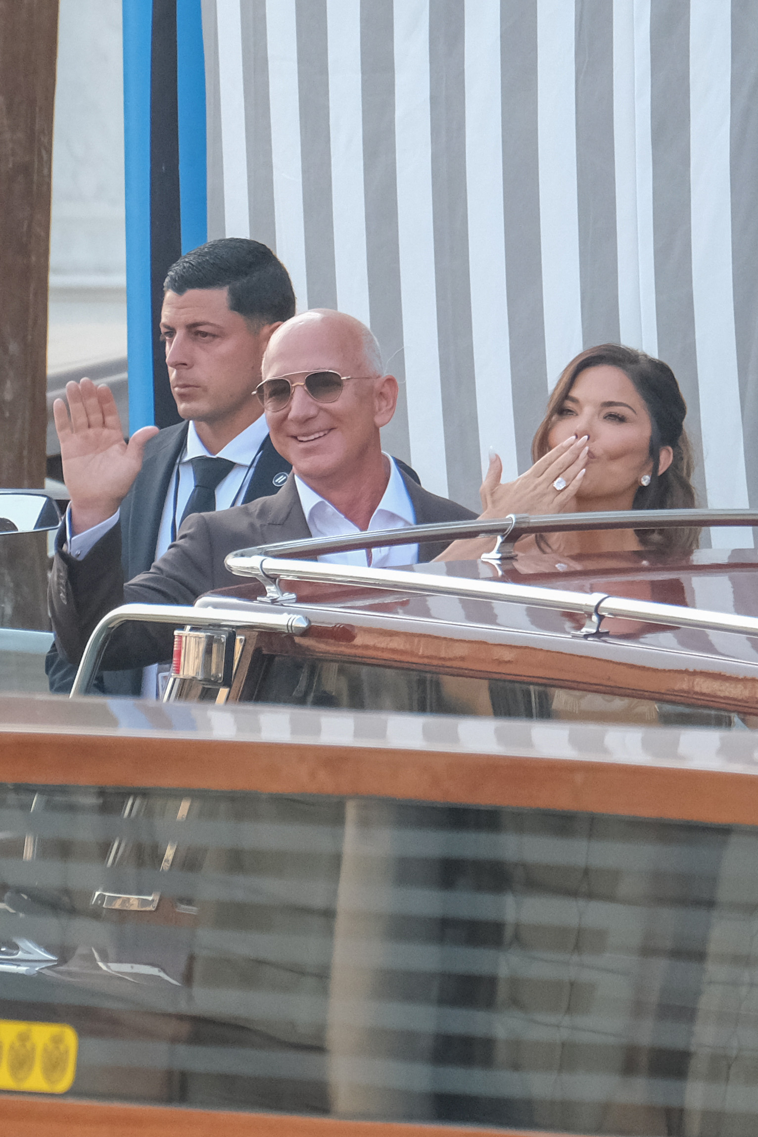 Jeff Bezos et Lauren Sánchez à bord d'un bateau, Sánchez envoyant un baiser à la foule. | Source : Getty Images