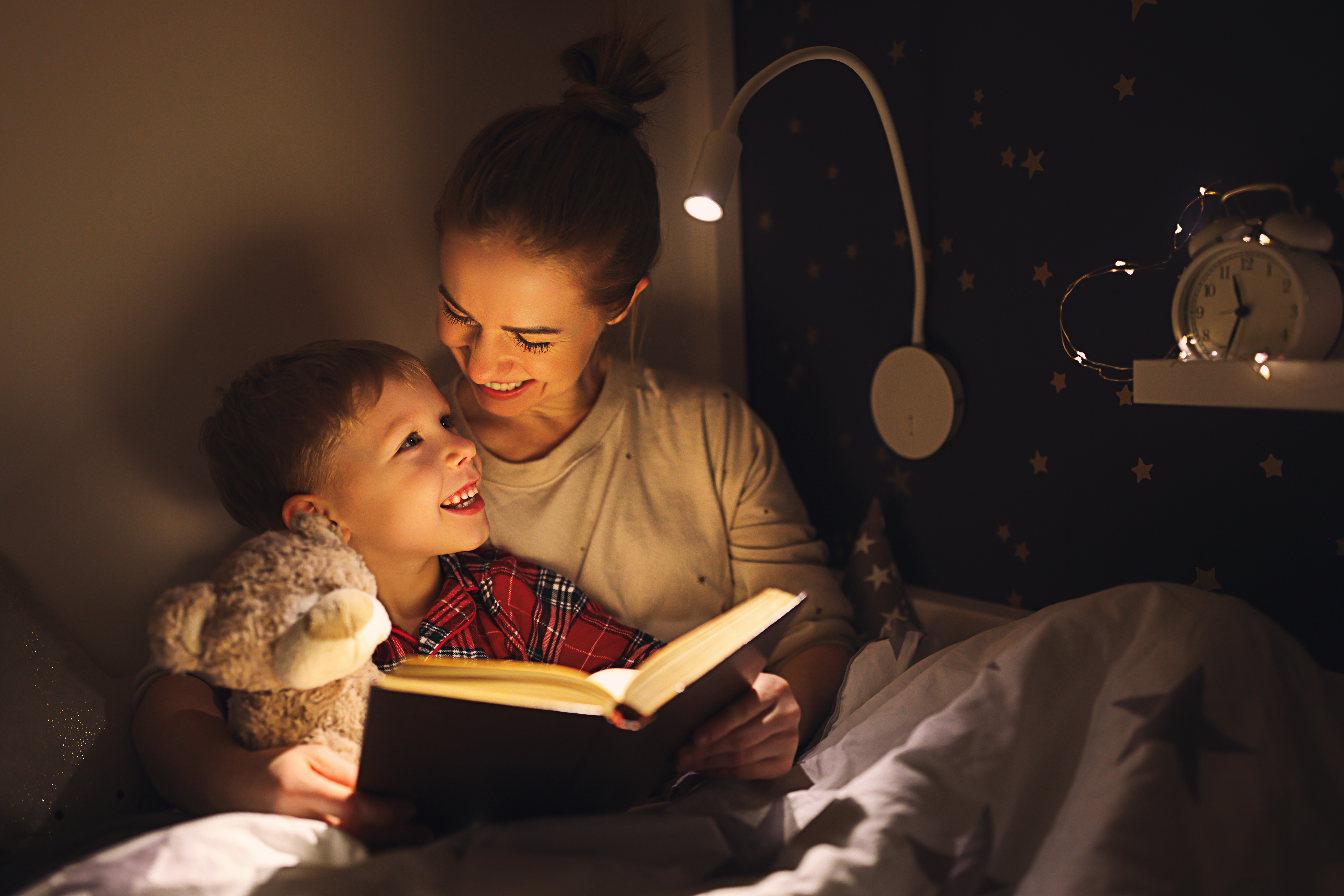 Une mère et son fils sont heureux de se câliner et de lire un livre | Source : Getty Images