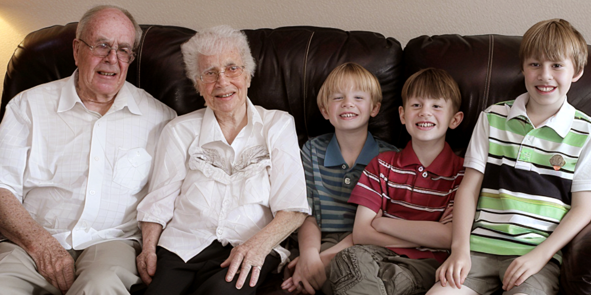 Grands-parents et petits-enfants assis sur un canapé | Source : AmoMama