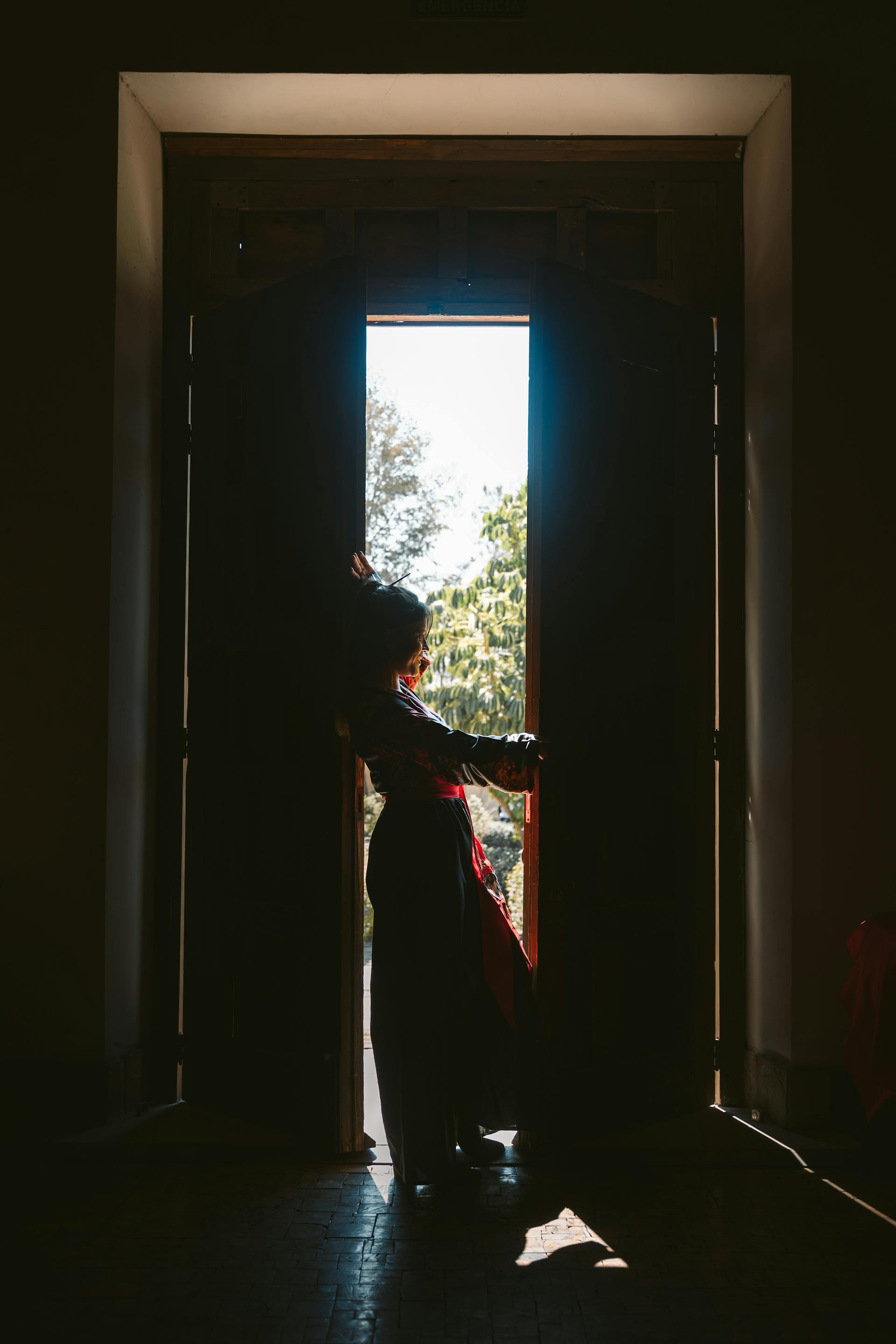 Une femme silhouettée dans l'embrasure d'une porte | Source : Pexels