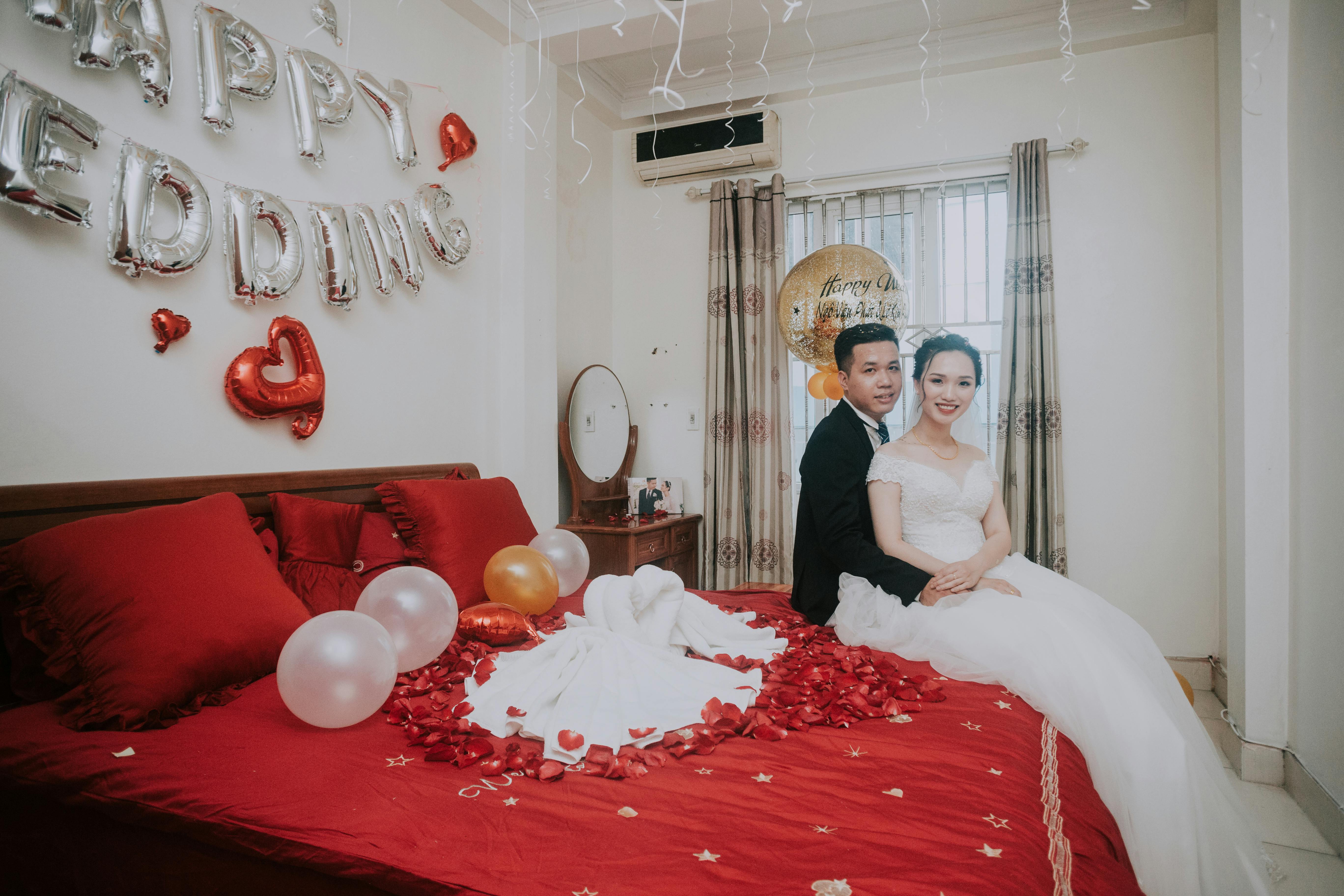 Un couple photographié sur le lit d'une chambre d'hôtel | Source : Pexels