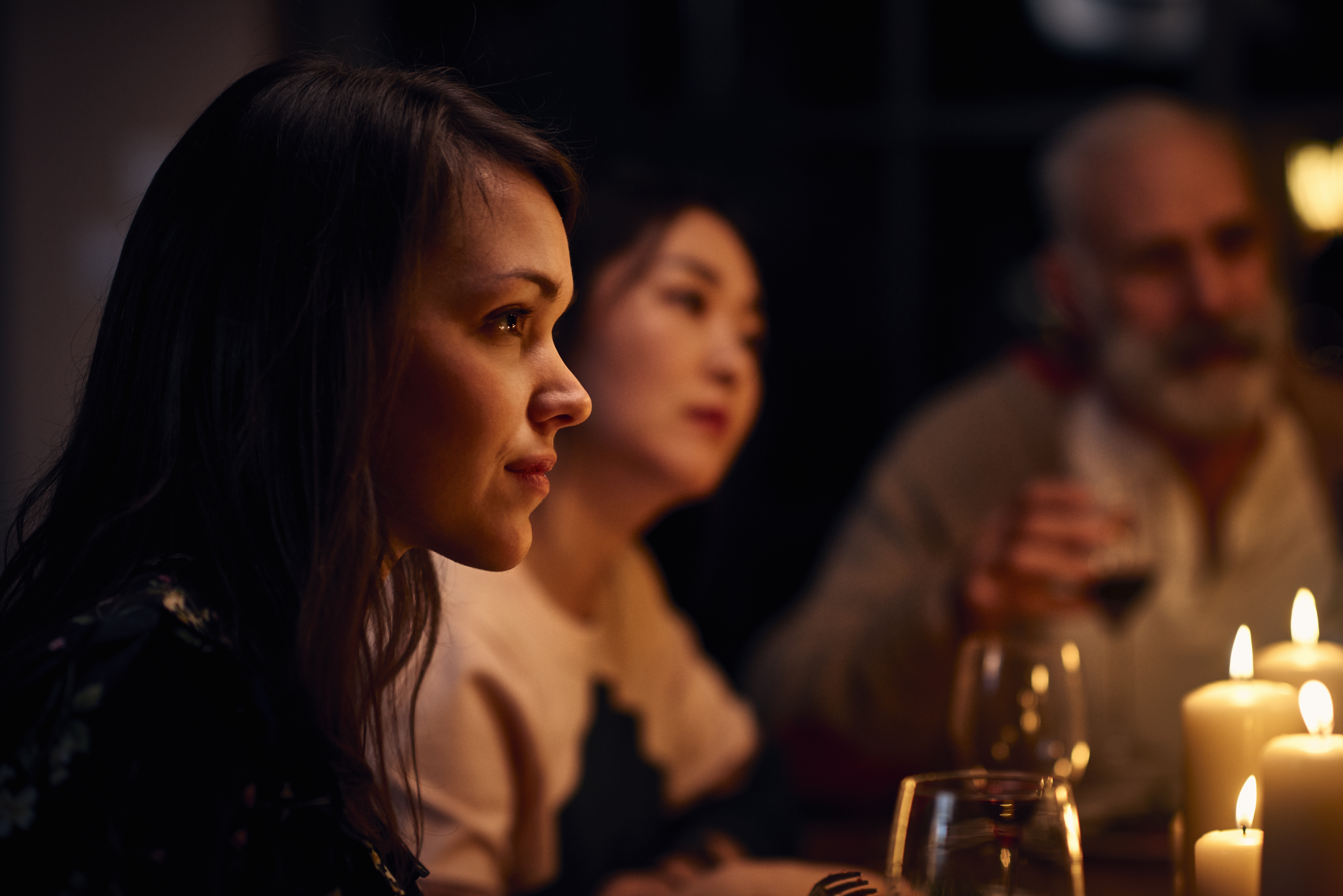 Femme à l'air sereine lors d'un dîner, écoutant attentivement | Source : Getty Images