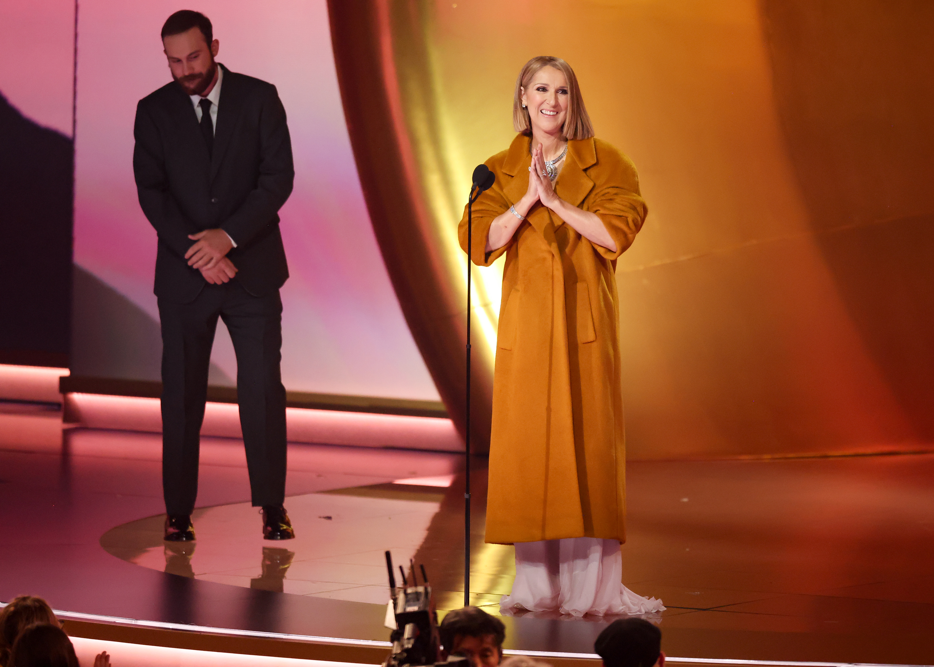 Rene-Charles Angélil se tient à l'écart de Céline Dion alors qu'elle prend la parole lors de la 66e édition des Grammy Awards à Los Angeles, le 4 février 2024.| Source : Getty Images
