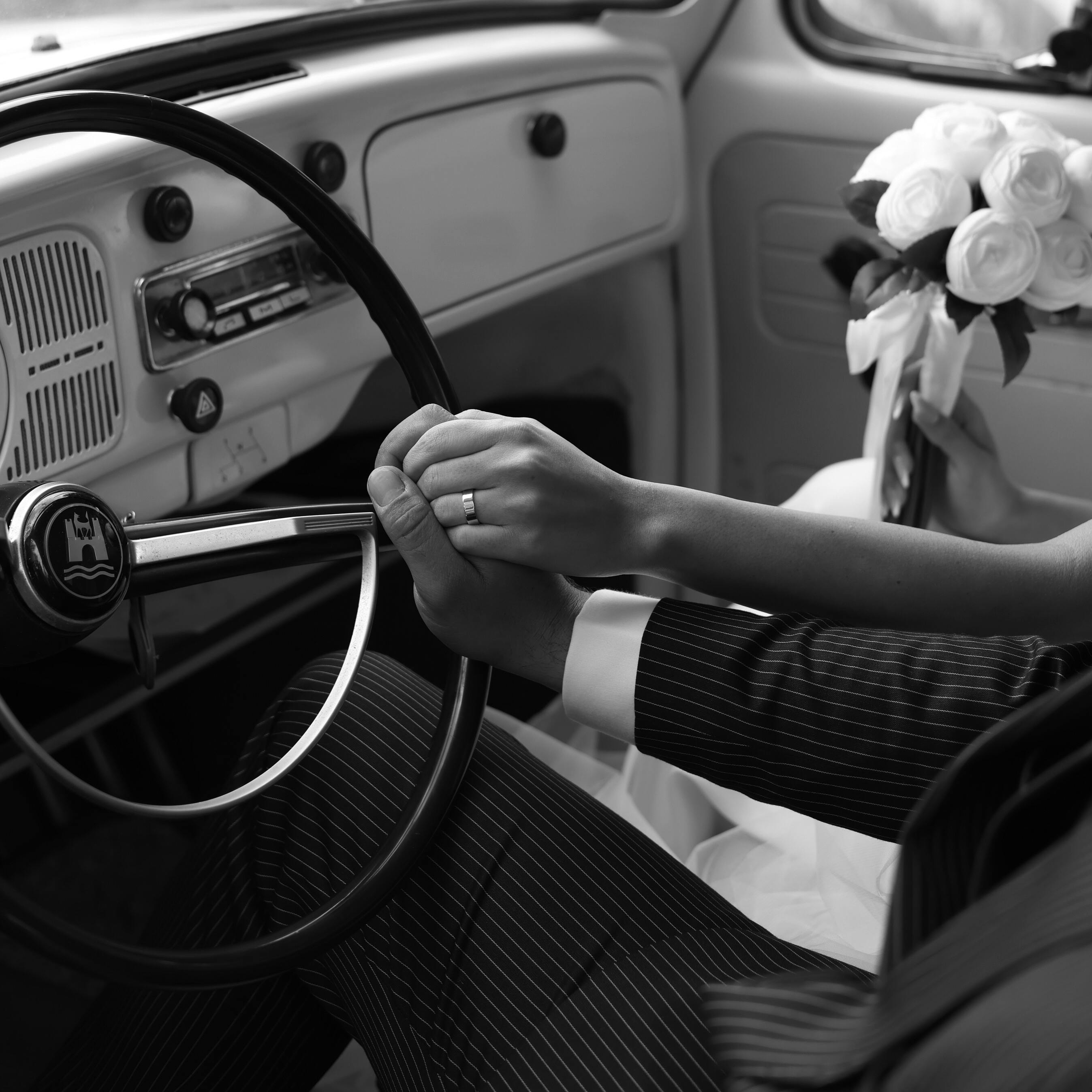 Une mariée et un marié se tenant la main sur un volant | Source : Pexels