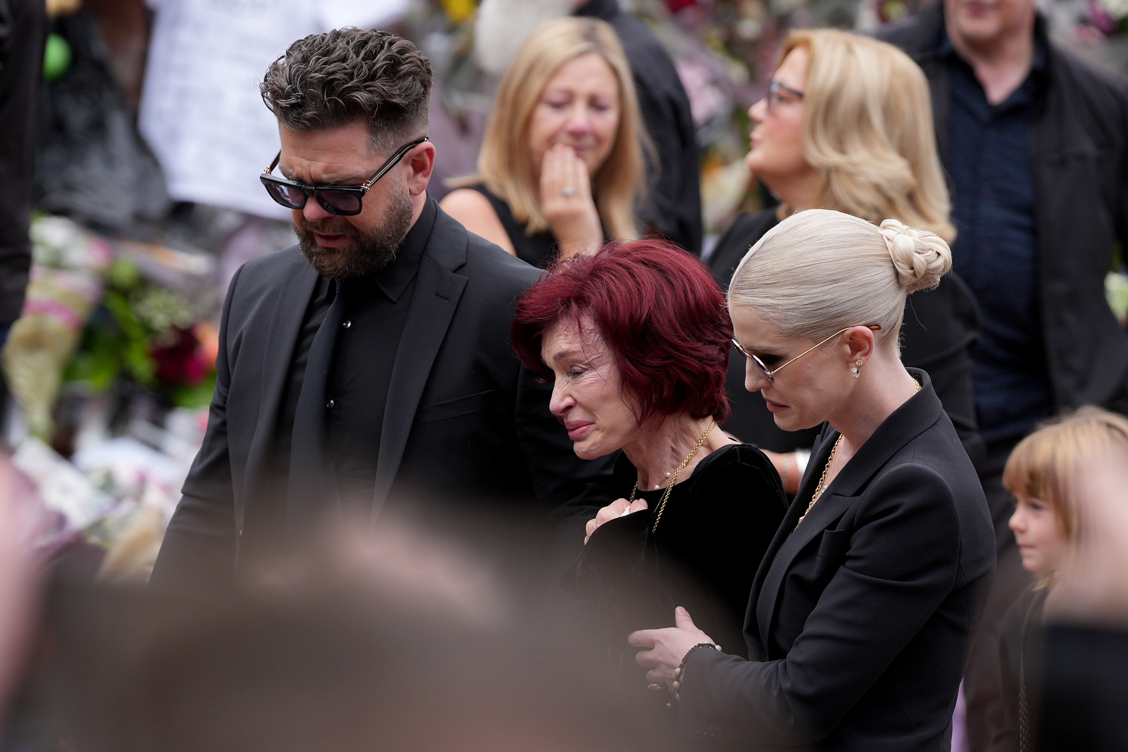 Jack, Sharon et Kelly Osbourne regardent les hommages rendus à feu Ozzy Osbourne par ses fans au Black Sabbath Bench and Bridge, le 30 juillet 2025, à Birmingham, en Angleterre. | Source : Getty Images
