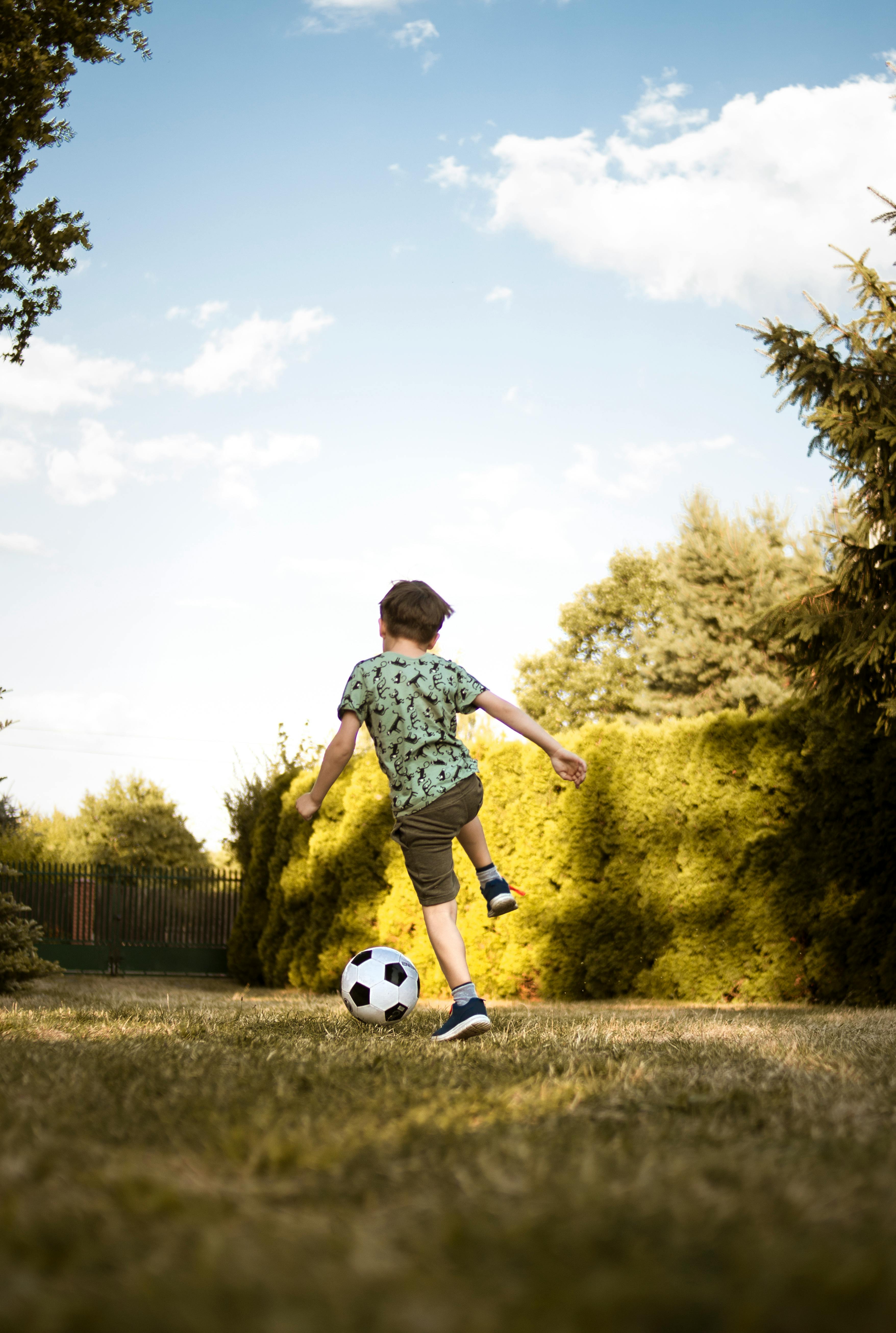 Un garçon qui joue avec un ballon de foot | Source : Pexels