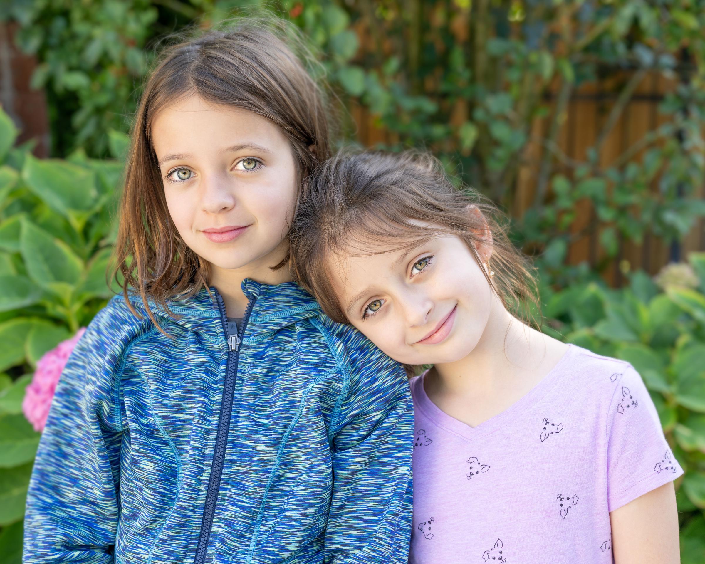 Deux jeunes filles sourient en plein air, rayonnantes d'amitié et de joie | Source : Pexels