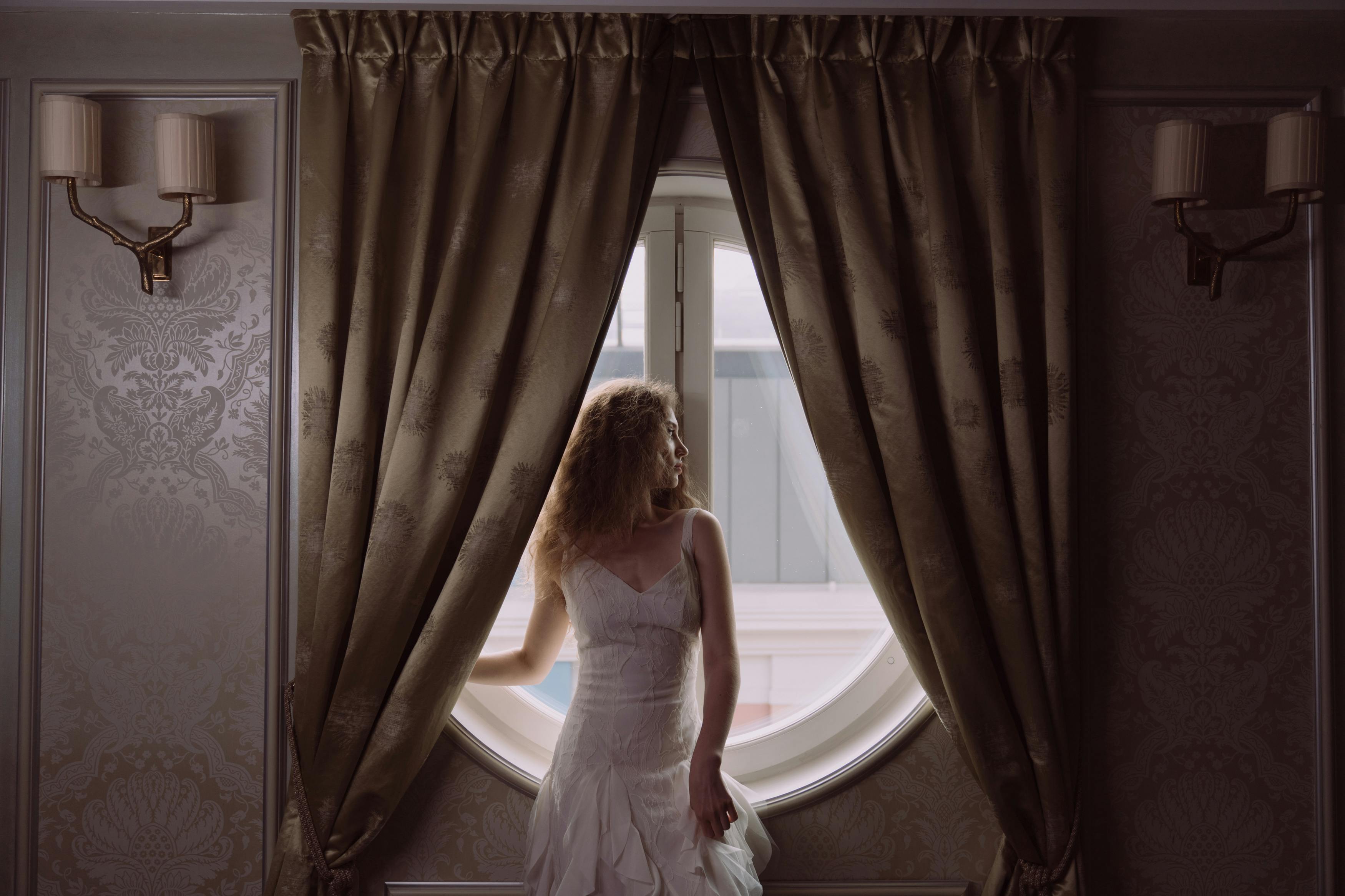 Une mariée regardant par la fenêtre |Source : Pexels