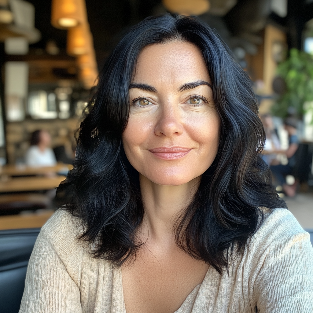 Une femme souriante assise dans un café | Source : Midjourney