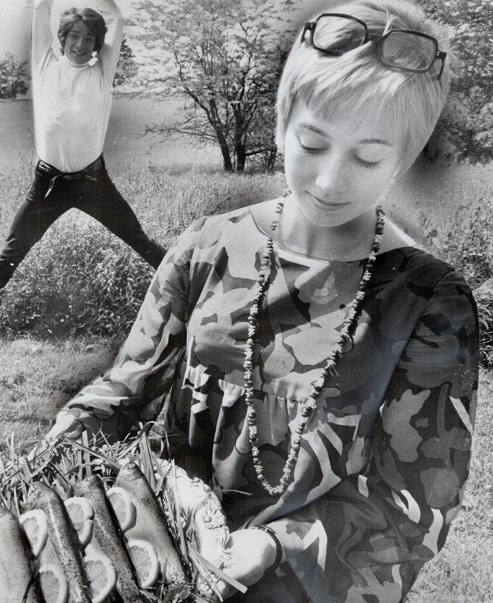 Sandy Duncan tenant une assiette de truites avec Jon Stevens en arrière-plan en 1968, au Canada | Source : Getty Images