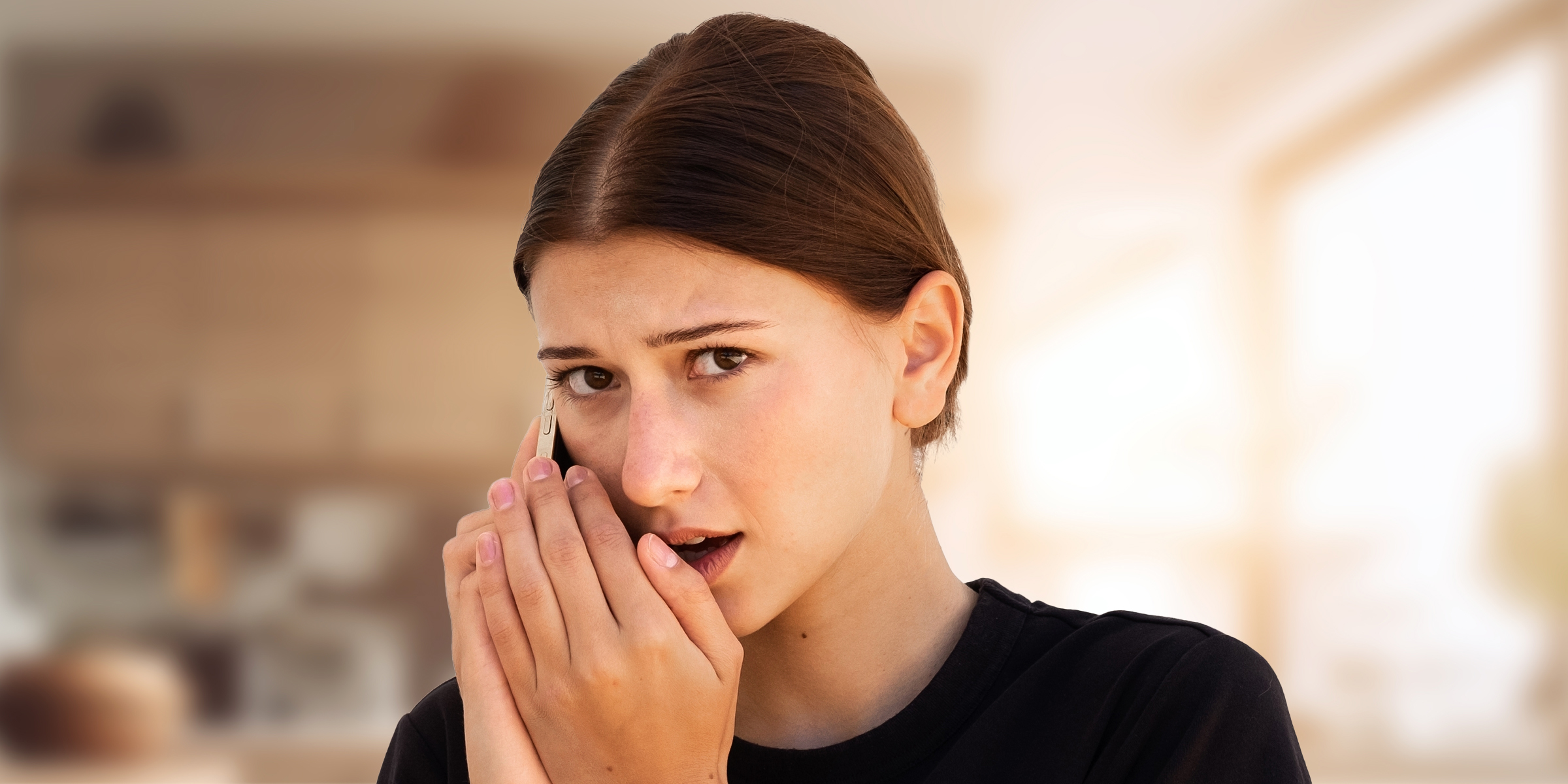 Une jeune femme parlant secrètement sur son téléphone | Source : Shutterstock