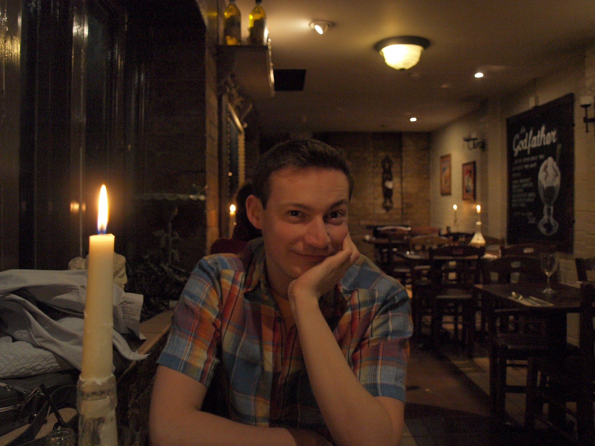 Un homme souriant et l'air heureux alors qu'il se fait prendre en photo dans un restaurant | Source : Flickr
