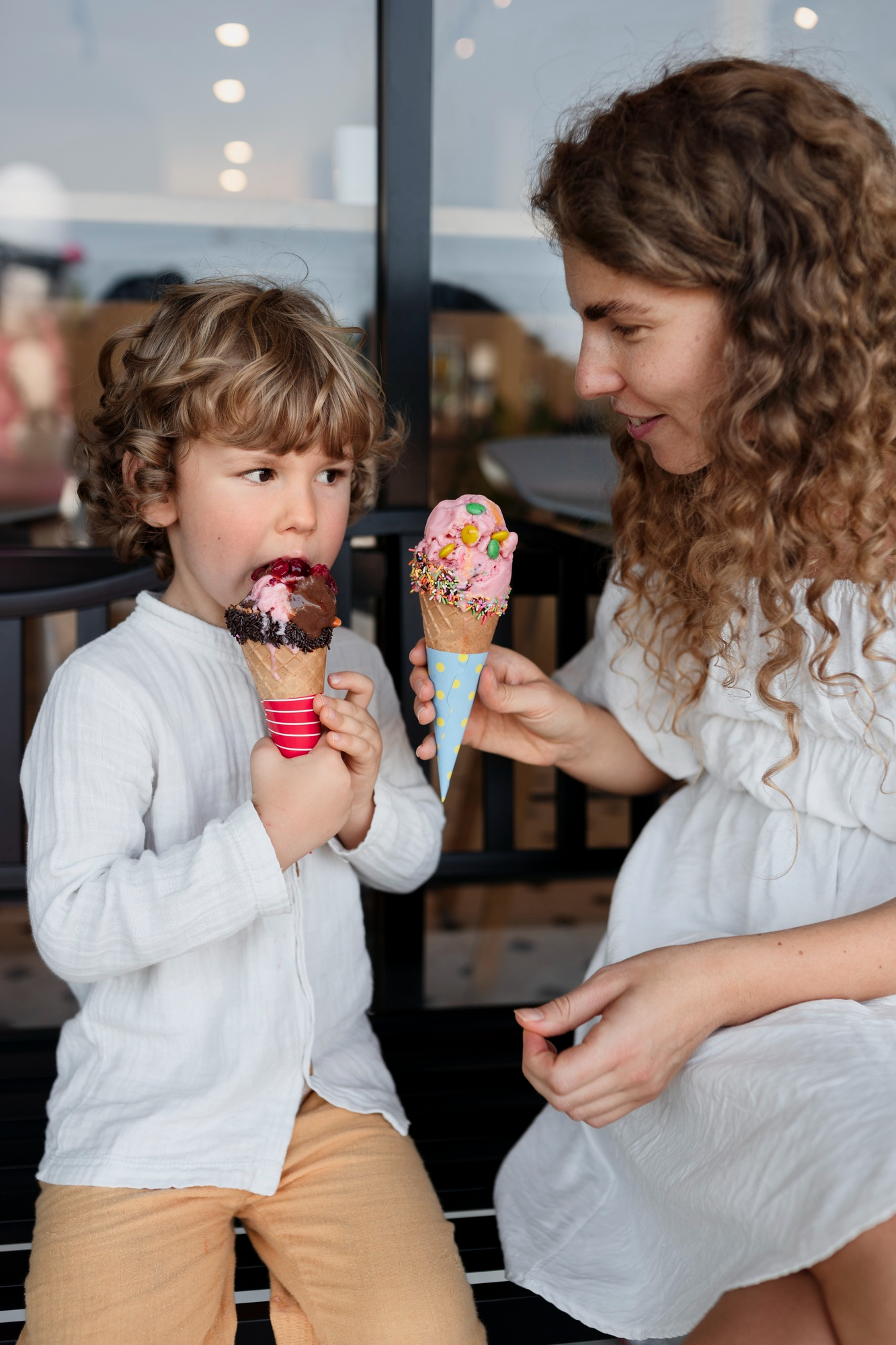 Une femme donne des cornets de crème glacée à un petit garçon | Source : Freepik