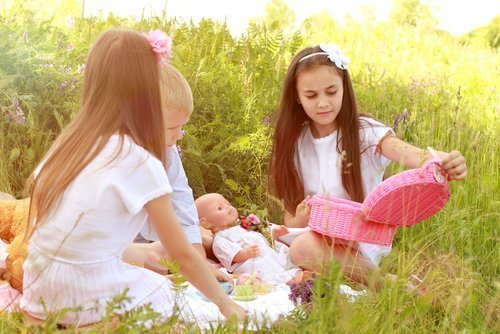 Des filles jouent avec leurs poupées en plein air. | Photo : Shutterstock.