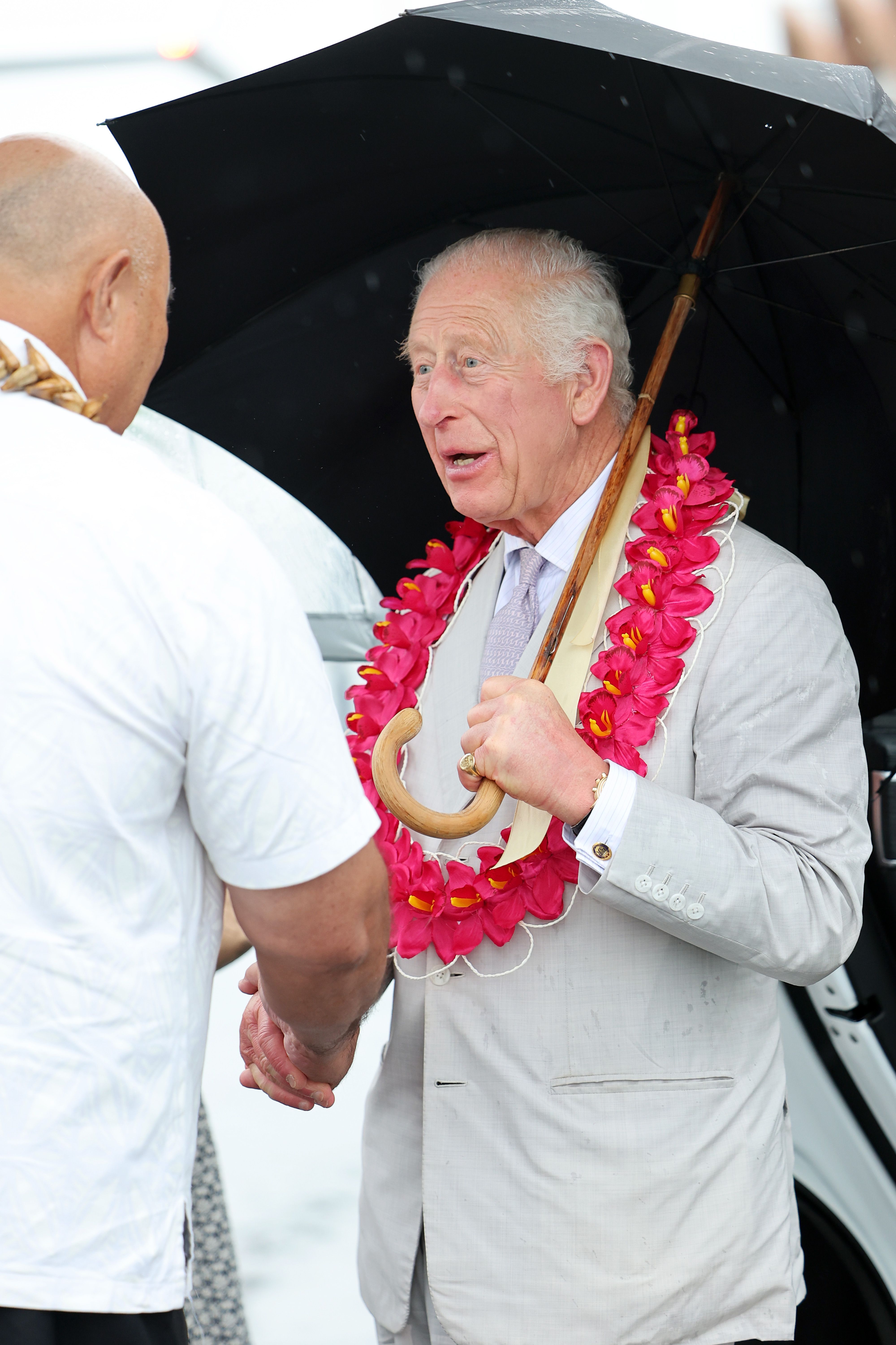 Le roi Charles III interagit avec un Samoan avant de monter à bord du jet de la Royal Australian Air Force après les adieux. | Source : Getty Images