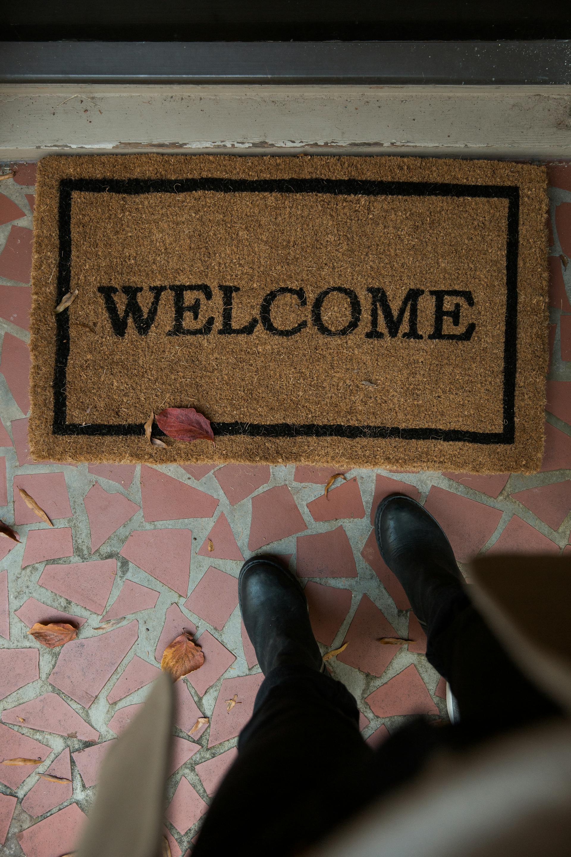 Une personne se tenant devant un tapis de bienvenue | Source : Pexels