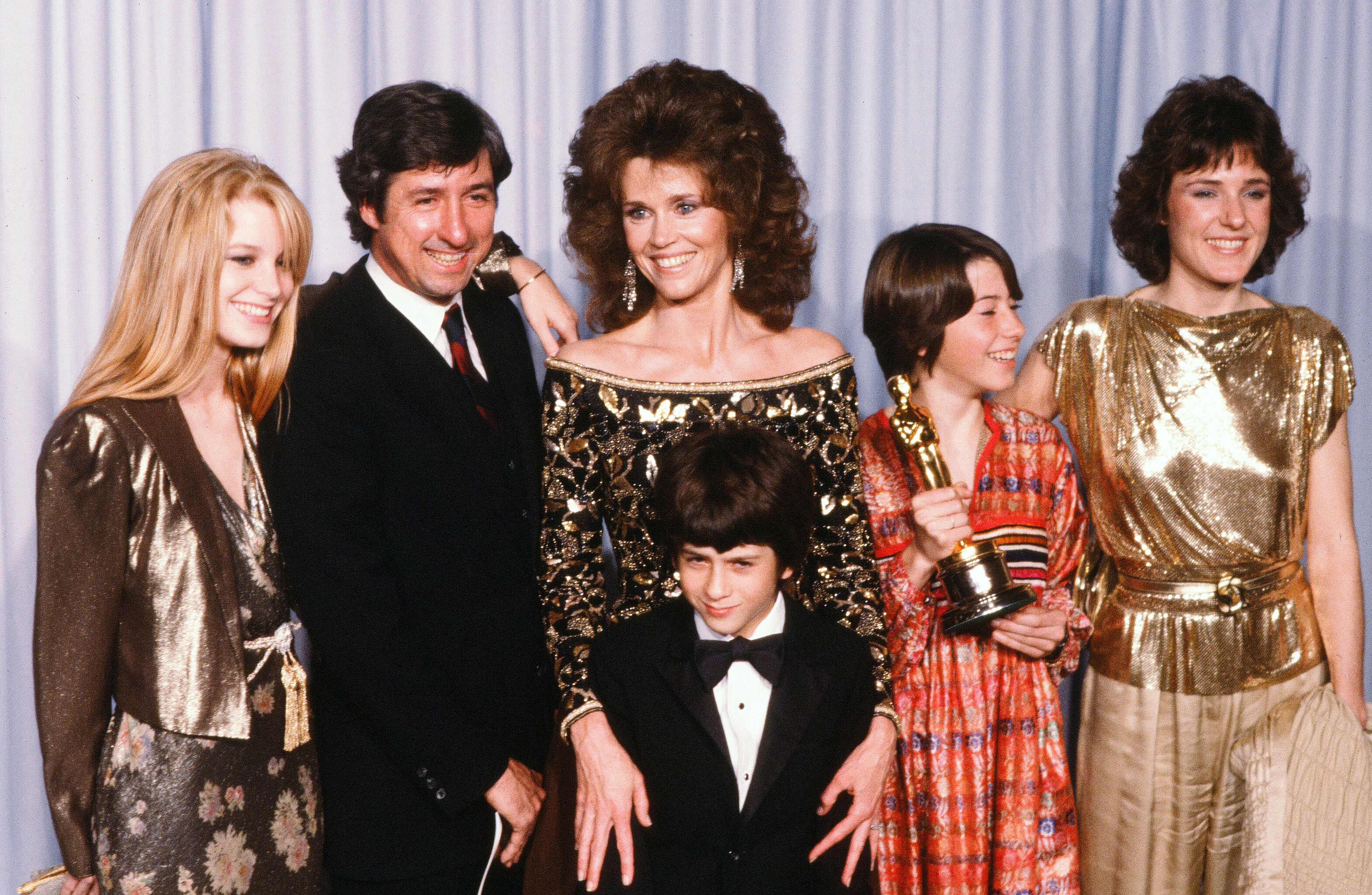 Jane Fonda avec Tom Hayden et sa famille, Bridgette Fonda, Troy Garity, Vanessa Vadim et Amy Fonda pose en coulisses après avoir accepté le prix du meilleur acteur décerné par son père Henry Fonda lors de la 54e cérémonie des Oscars au Dorothy Chandler Pavilion à Los Angeles. | Source : Getty Images