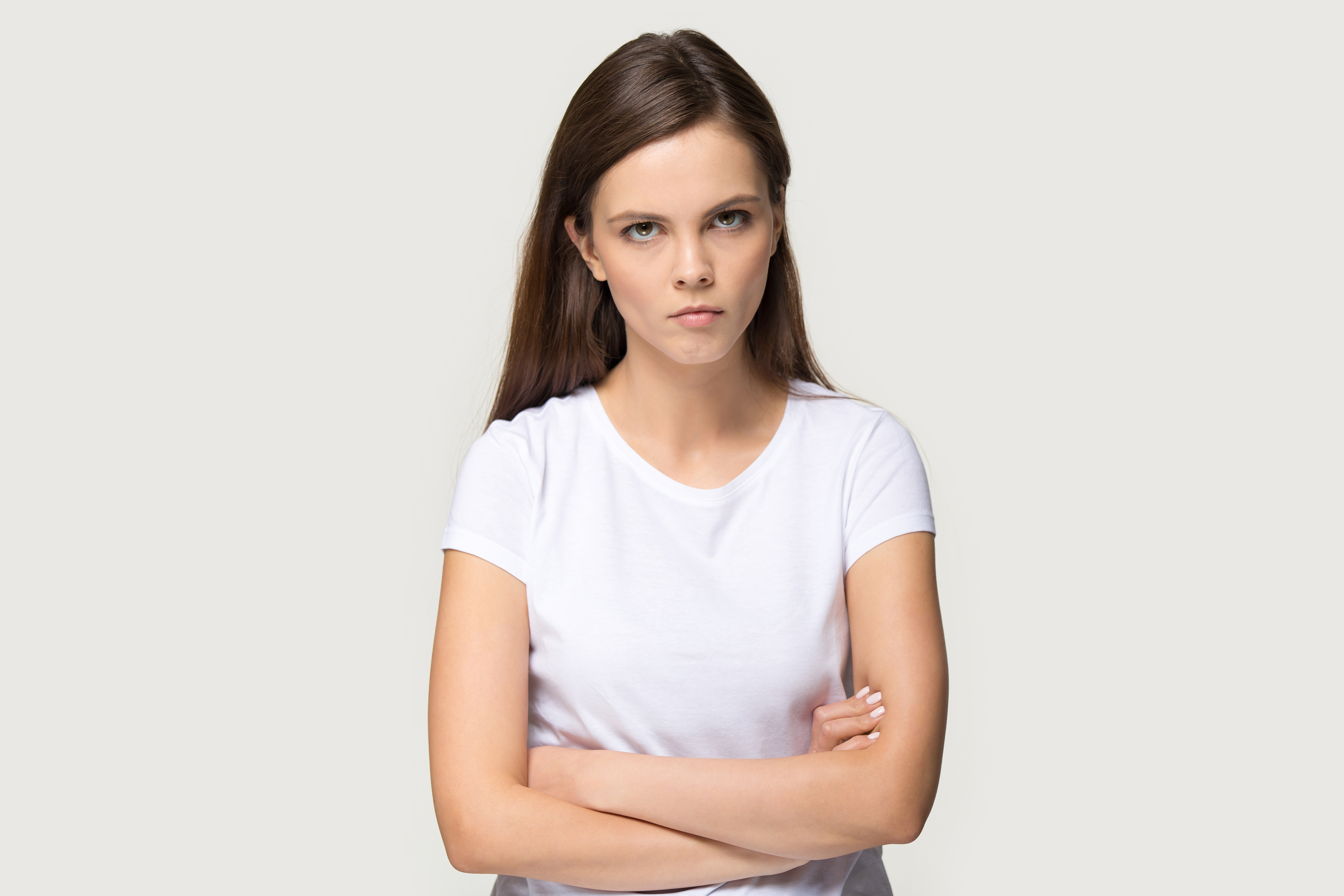 Une jeune femme en colère debout, les bras croisés | Source : Shutterstock