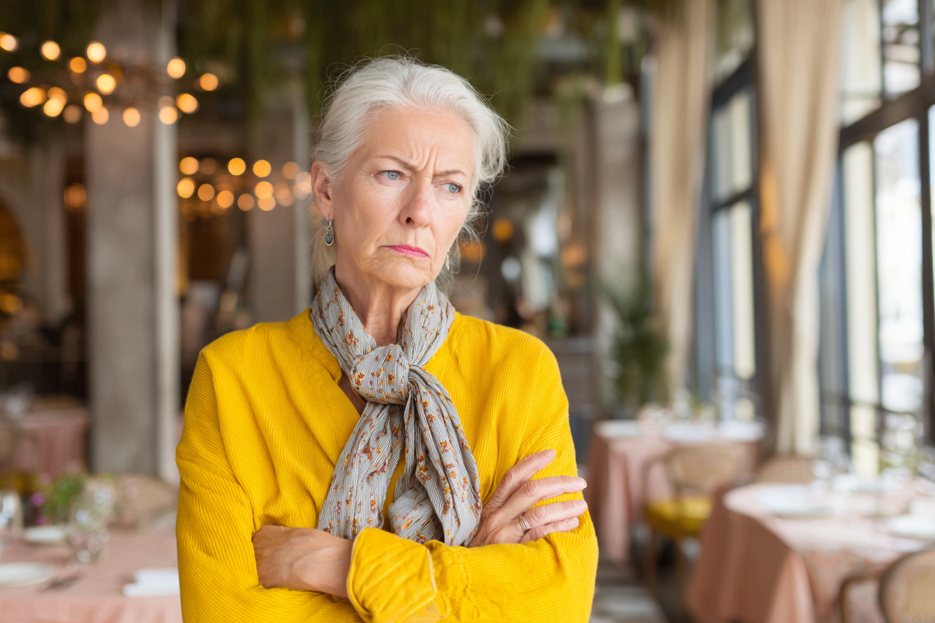 Une femme en colère debout dans un hôtel-restaurant | Source : Midjourney
