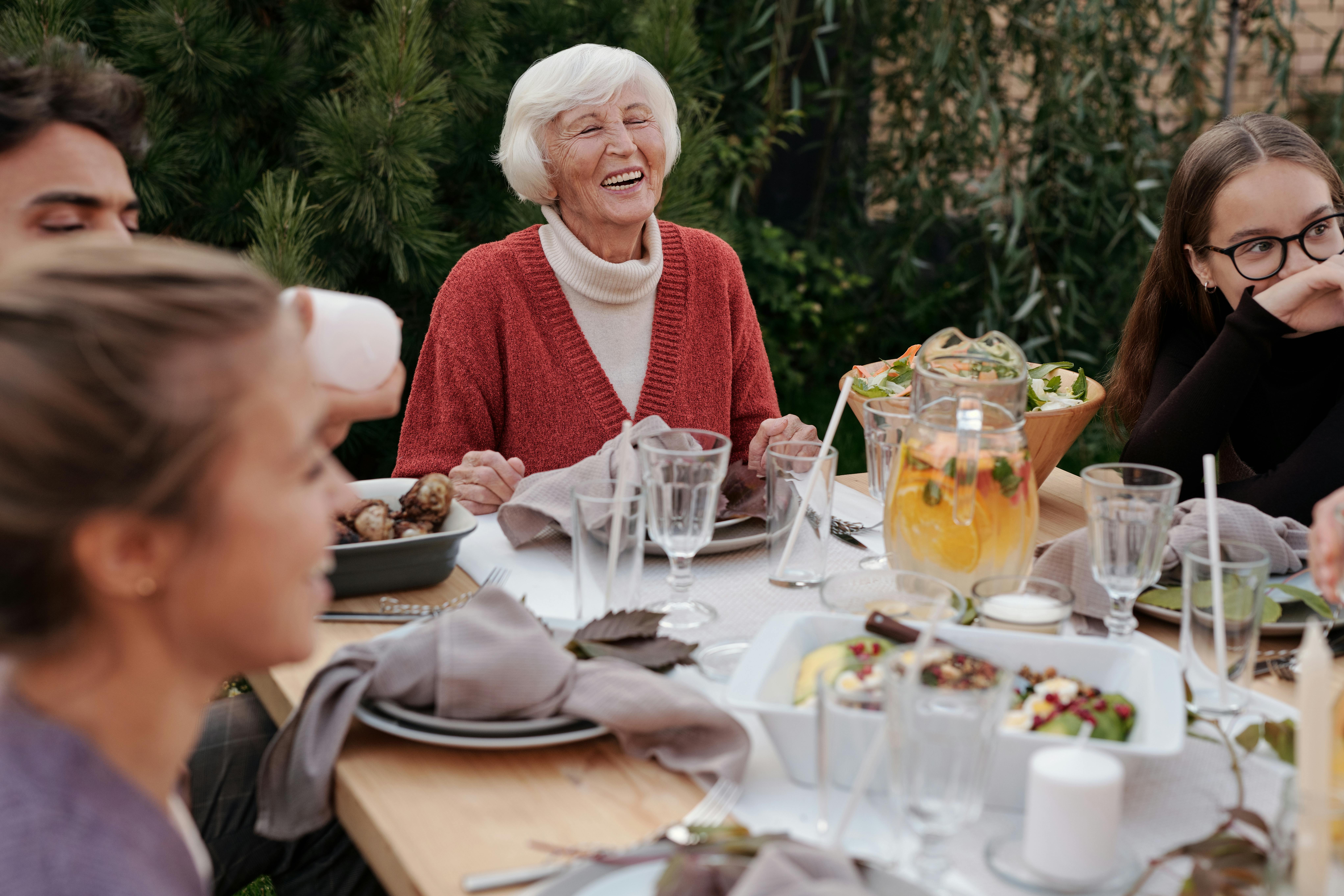 Une famille réunie autour d'une table, discutant et mangeant | Source : Pexels