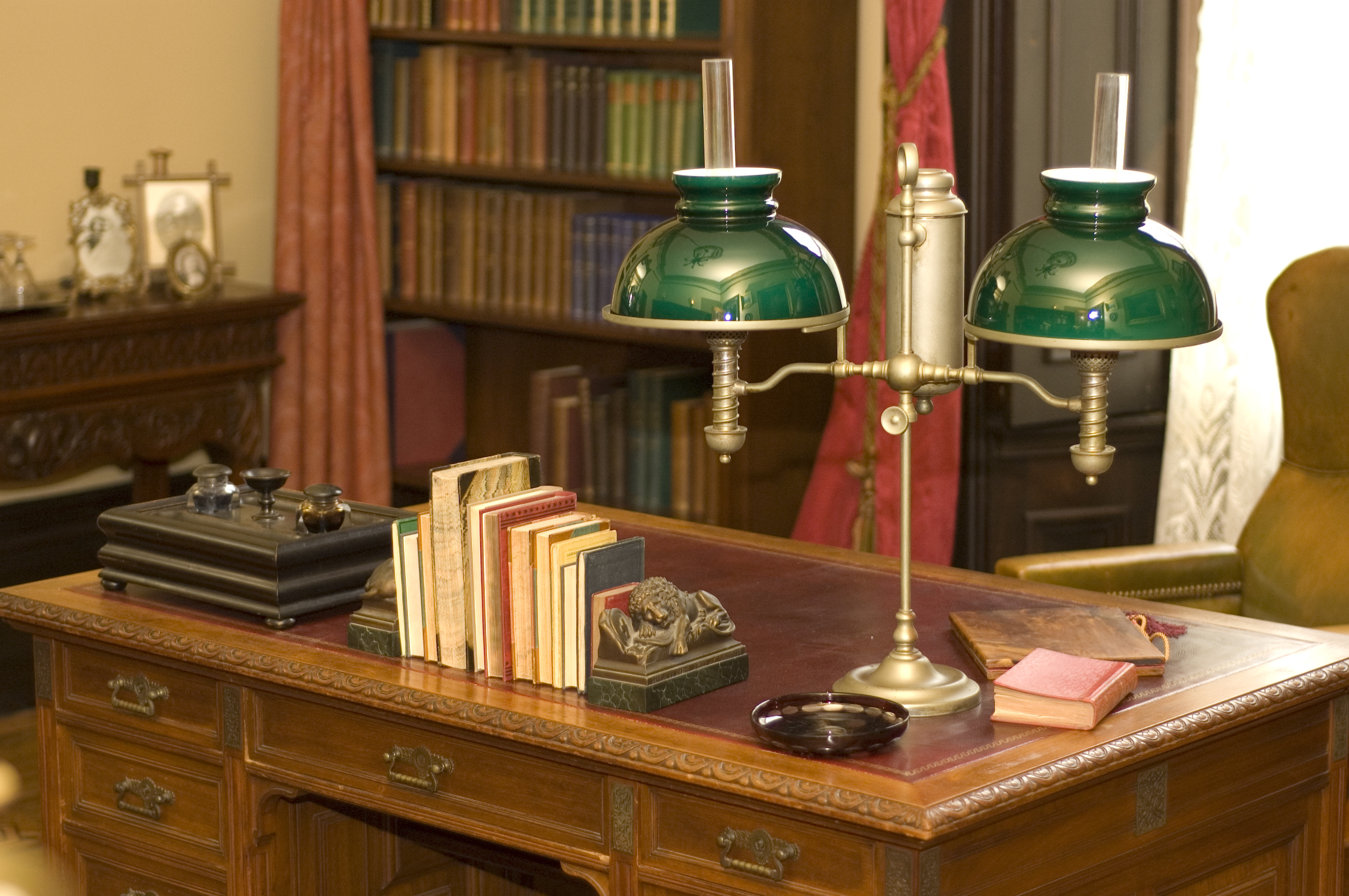 Une lampe à huile classique et des livres placés sur un bureau antique | Source : Shutterstock