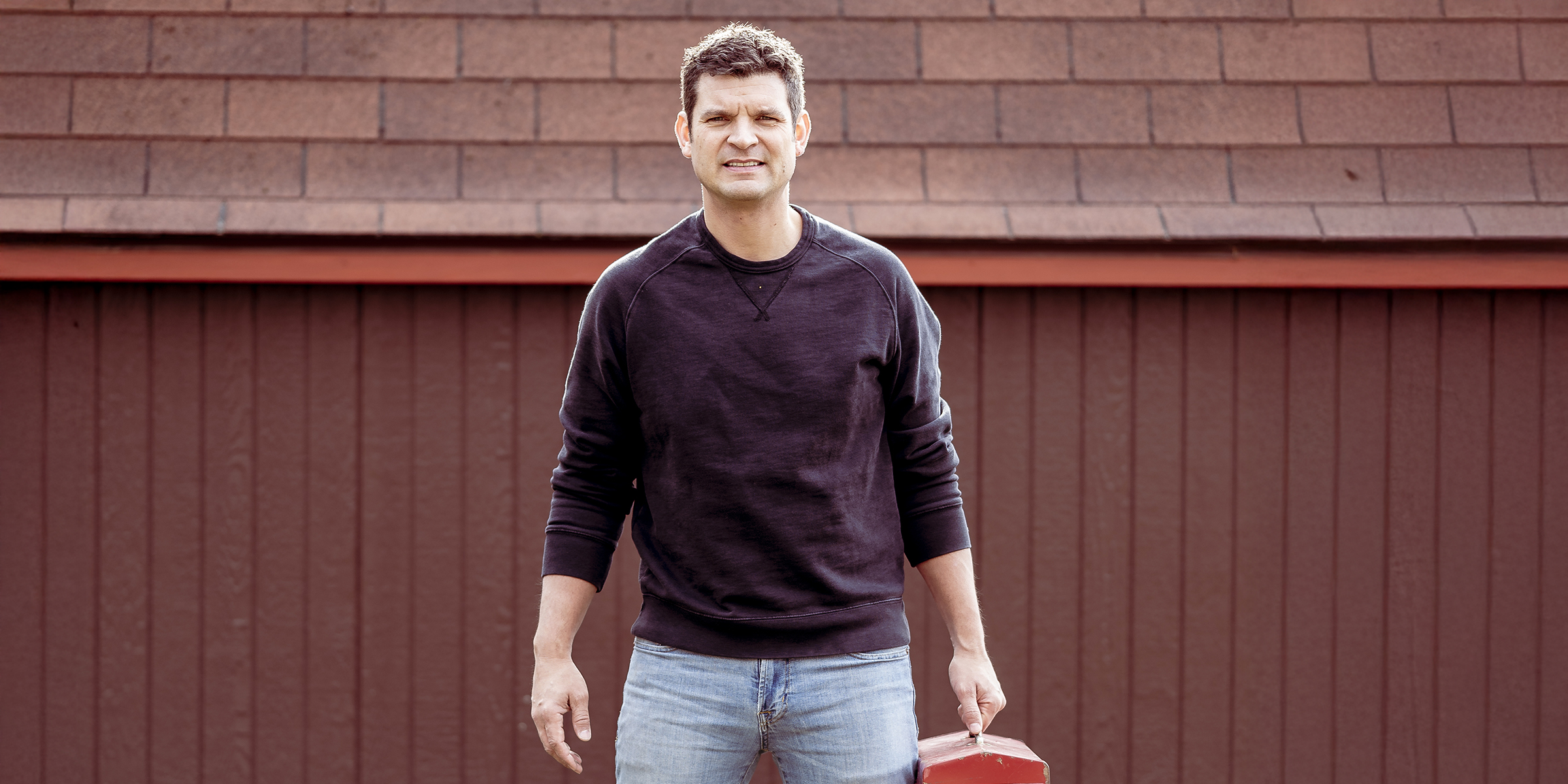 Un homme debout devant un garage | Source : Shutterstock