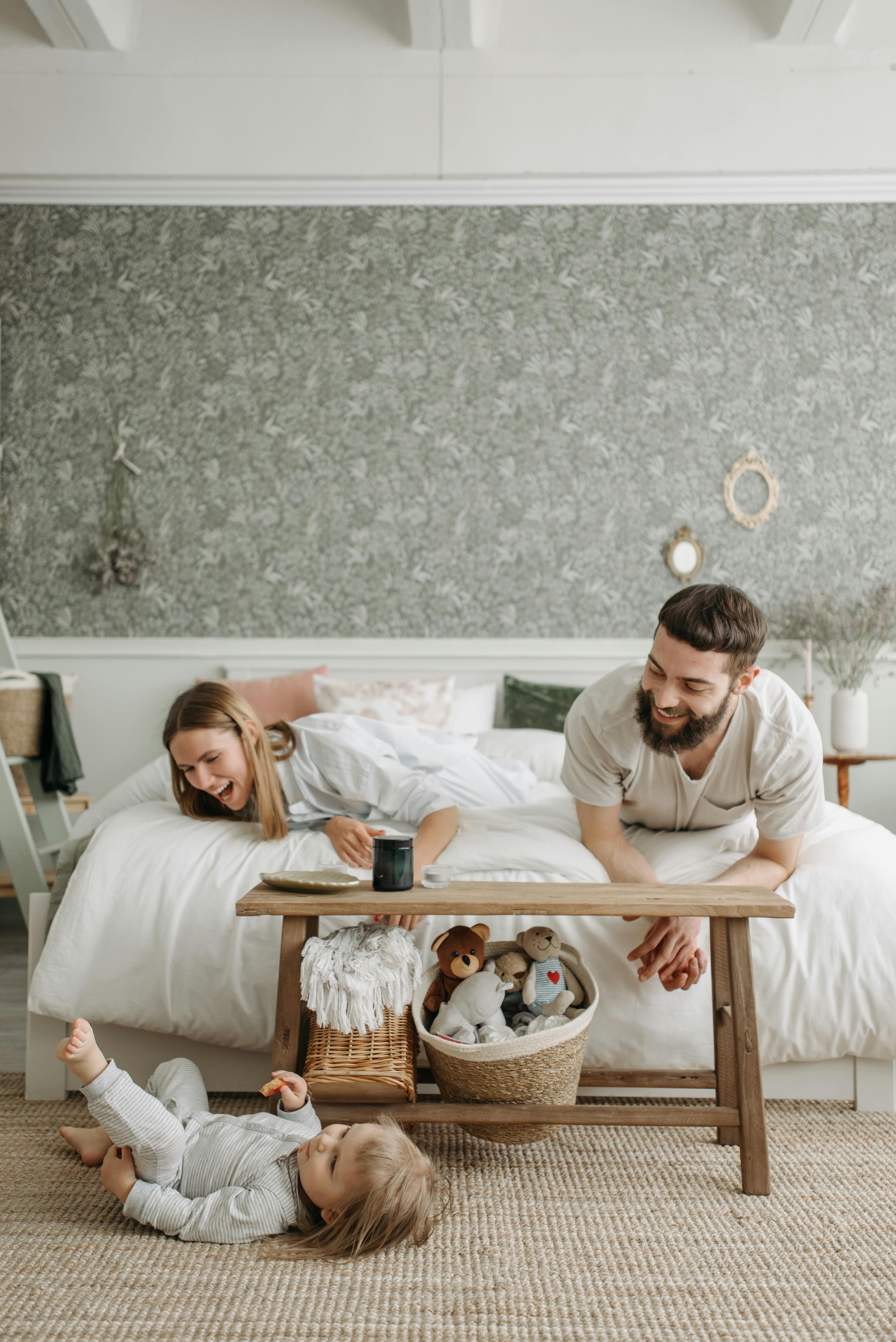 A man and a woman watching a baby play | Source: Pexels