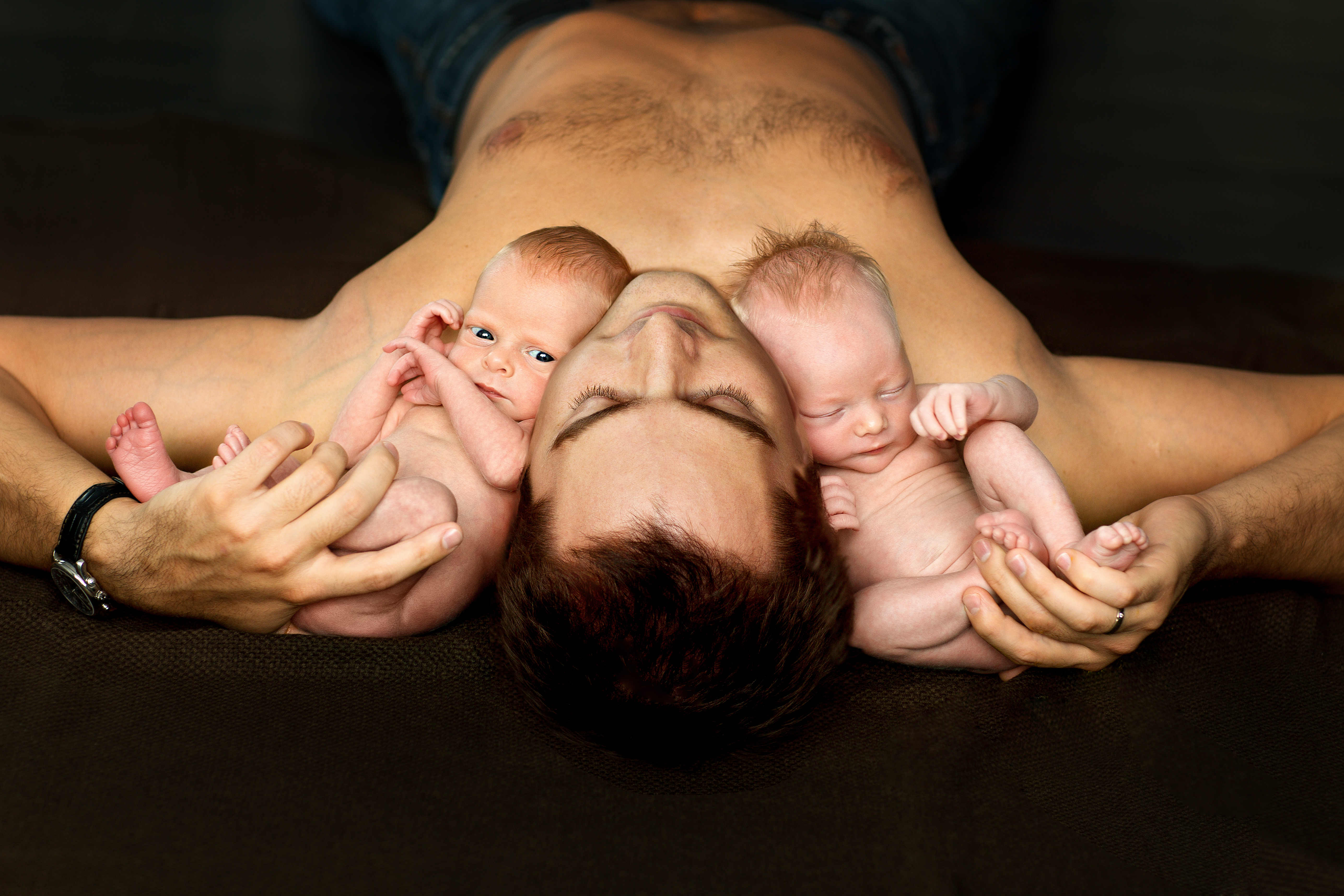 Un hombre con dos bebés. | Fuente: Shutterstock
