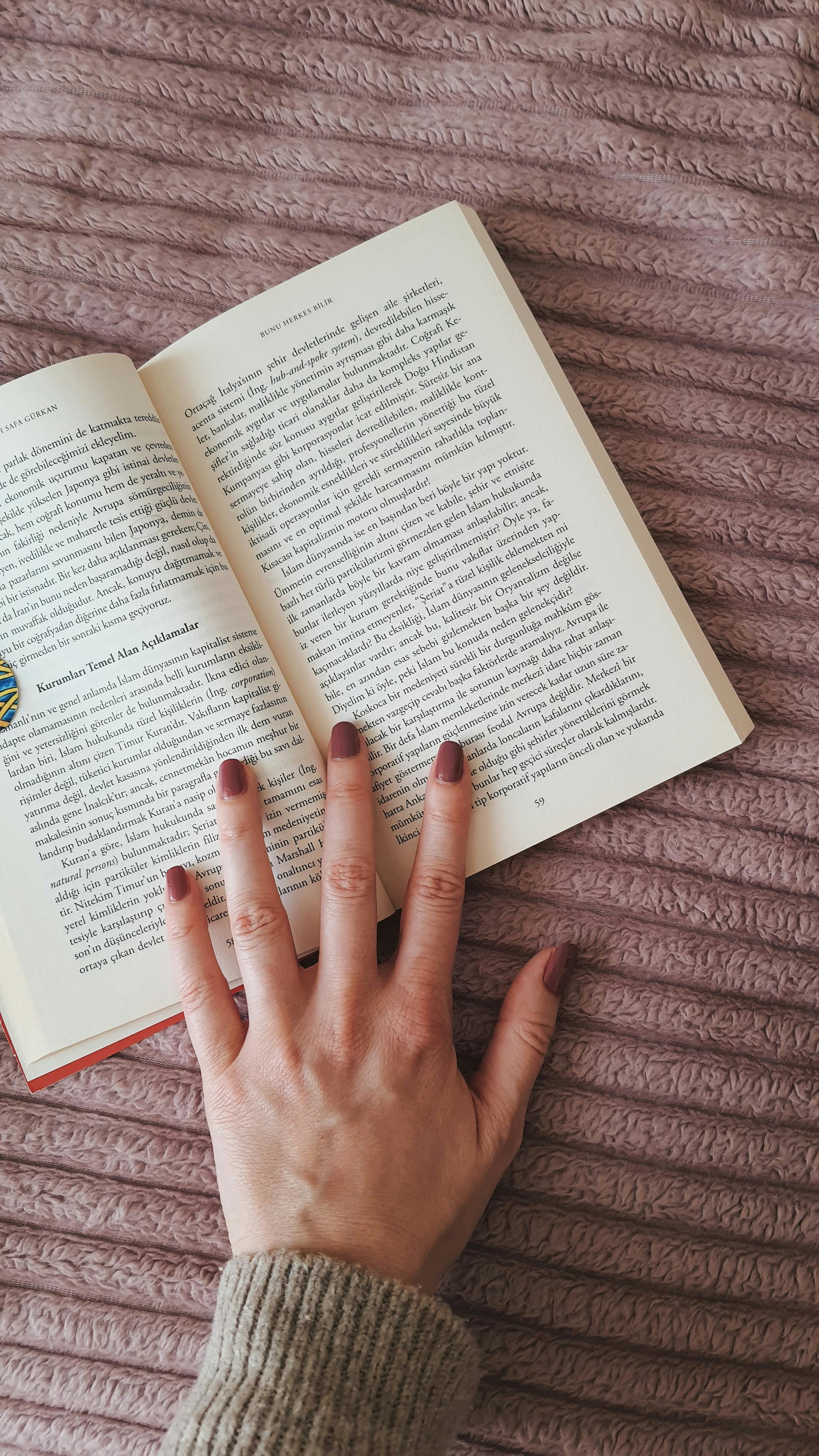 La main d'une femme sur un livre | Source : Pexels