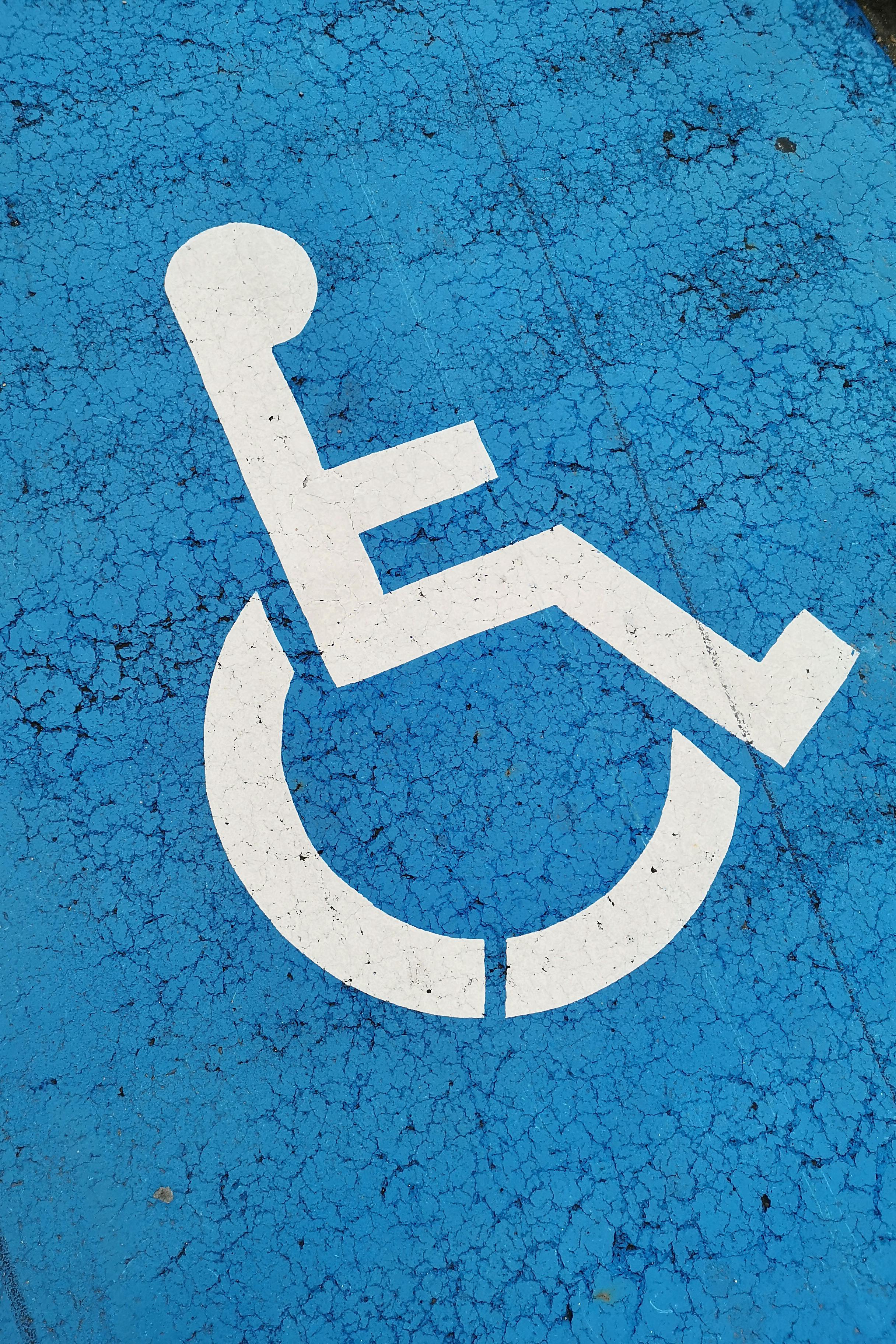 Marquage au sol indiquant une aire de stationnement adaptée aux personnes handicapées | Source : Pexels